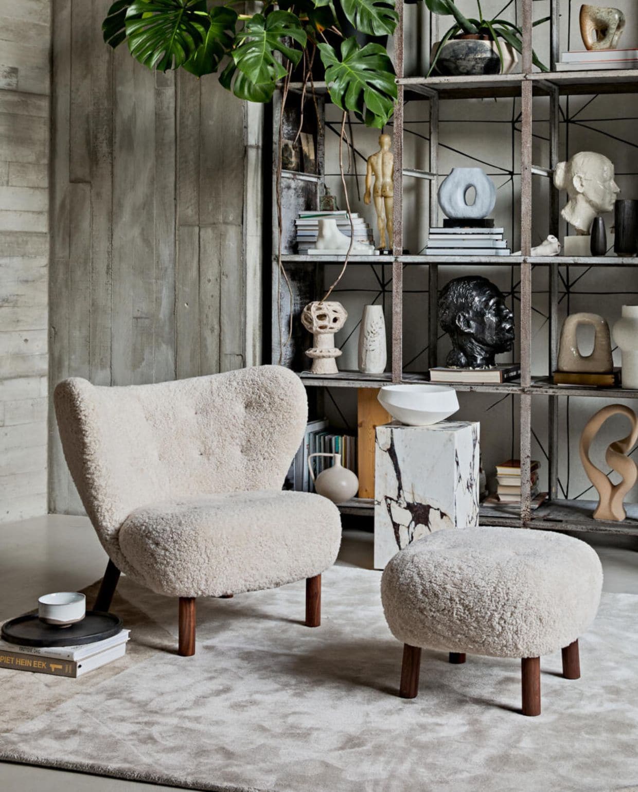 Keramieken vloerlamp retro cone xl, 40×140 cm (Øxh) € 449,- (hkliving.nl). Fauteuil en voetenbank met schapenvacht Little Petra van &amp;Tradition € 6113,-(kasstoor.nl). Vloerkleed Volume van Fest Amsterdam € 699,-, dienblad van Zone Denmark. 35 cm (Ø) € 50,-, kom van Merci n°1 van Serax, 12,5 cm (Ø) € 16,65 (vtwonen.nl). Marmeren bijzettafel Plinth Tall van Menu, 30x30x51 cm (lxbxh) € 999,95 (designtales.nl). Erop: schaal € 59,95 (urbannatureculture.nl). Behang achter kast JO2703-2 Tres Tintas, Cuzco per m² € 45,- (rebelwalls.com). In de kast, van onder naar boven: crème vaas met oor € 34,95 (hkliving.nl). Ecru sculptuur Stoneware van Bloomingville € 85,- (vtwonen.nl). Zandkleurige keramieken kaarsenstandaard Arch van Malwina Kleparska € 275,- (studio-yen.com). Vaas speckled round, 30 cm (h) € 39,95, polystone voet € 59,95 (hkliving.nl). Blauwe vaas met gat € 37,95 (vtwonen.nl). Stenen sculptuur € 900,- (lisette­leegwater.nl). Vintage hoofden en overige objecten (vintagehoarder.com). Wandbekleding en kast van locatie. JA | vtwonen 02-2021 | styling Cleo Scheulderman | fotografie Jeroen van der Spek