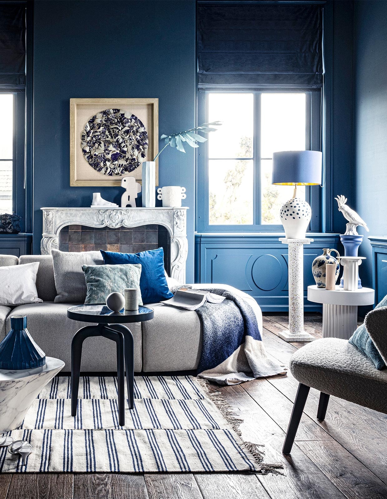 Voet op schouw € 59,95, sierobject op schouw € 58,95, pilaar € 239,-, witte bijzettafel € 269,-, witte vaas € 38,35, schilderij prijs op aanvraag (hkliving.nl). Velours stoel € 1200,- (edha-interieur.nl). Kleed € 199,- (zarahome.com). Marmeren salontafel € 587,50, blauwe tak € 57,- (polspotten.nl). Blauwe salontafel van Schönbuch € 719,-, plaid van Mae Engelgeer € 440,-, wit kussen van Mrs.me € 99,- (homestede.nl). Blauw kussen € 49,-, ecru kussen € 49,-, blauw kussen op stoel € 49,- (couleurlocale.eu). Wandlamp Chicago van It’s about RoMi € 355,-, kussen Sarona vintage blue, 45×45 cm € 35,- (polspotten.nl). Velvet sierkussen, 55×55 cm € 74,-, donkerblauwe vaas met tak (klevering.nl). Zeshoekige vaas, hoogte 32 cm € 38,99, Kaketoe ornament € 53,-(polspotten.nl), bank Jax van HKliving, element vanaf € 499,- (vtwonen.nl). Blauwe vaas, smal toelopend € 469,-, cirkelvormig sierobject € 129,-, wit bakje op tafel, prijs op aanvraag, lichtblauwe vaas, hoogte 46 cm € 239,-, marmeren pot op blauwe salontafel € 45,-, opengeslagen boek € 40,- (badenbaden.nl). Stoel rechts € 1898,-, sierbal op blauwe tafel, set van 3 € 99,-, houten siervorm op bijzettafel, set van 3 € 99,- (covanderhorst.nl). Schoenen € 34,99 (hm.com). Lampenvoet met stippen € 798,-, gordijnstof 295 cm breed, per meter € 103,- (wva.nl). Blauw gevlekte vaas op bijzettafel € 235,95, blauwe kleine pilaar € 66,55, blauwe lampenkap € 332,75, wandbord per 2 € 235,95, marmeren schouw Lodewijk XIV € 15.125,-, 18e-eeuwse houten vloer, per m² € 168,19 (pietjonker.nl). Witte vaas van Serax op schouw € 40,85 (loods5.nl). Overig privébezit. JA | vtwonen 07-2020 | styling Liza Wassenaar | fotografie Sjoerd Eickmans