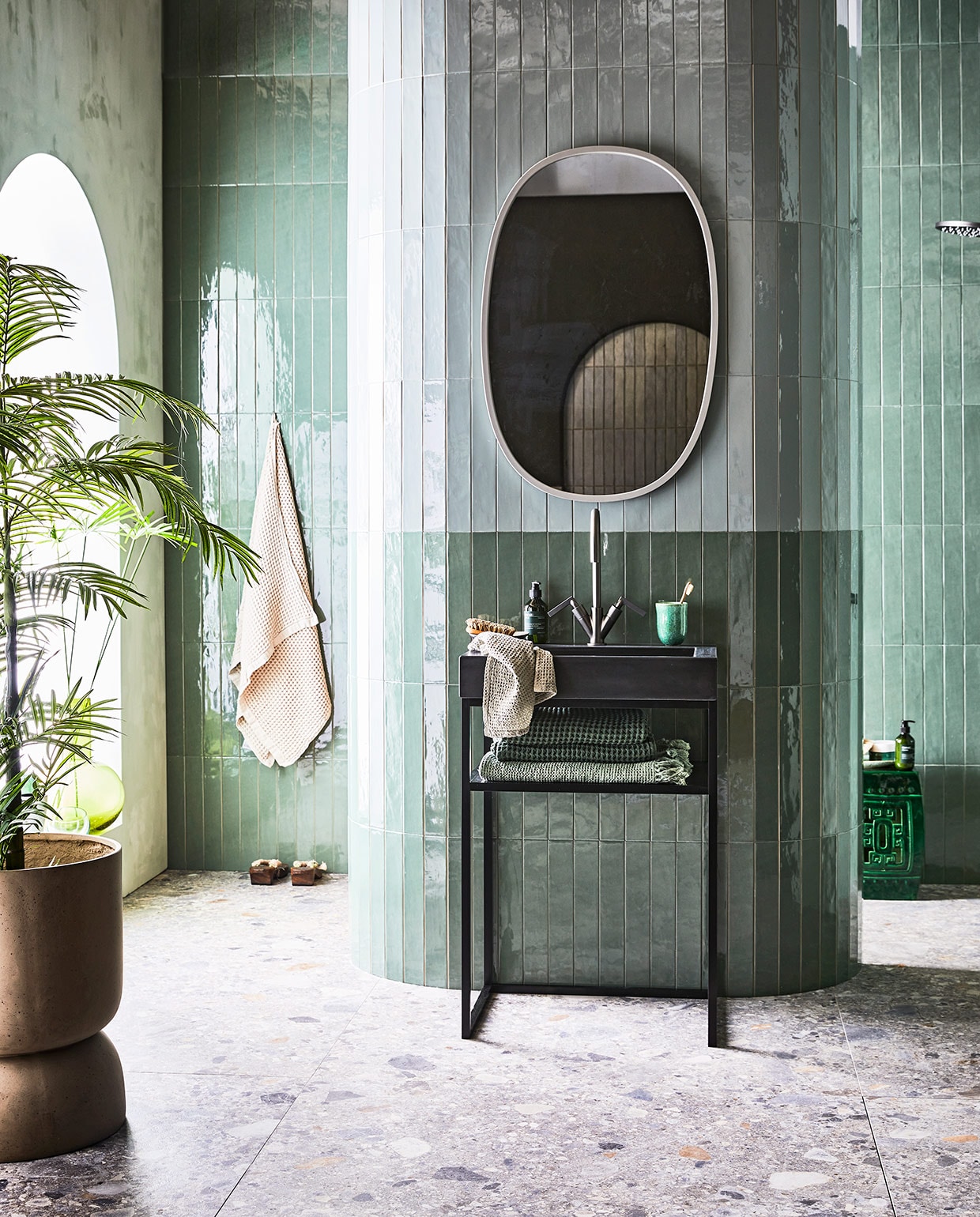 kleur Seagreen, glans, 6,5×40 cm. Donkere wandtegel Marrakesh, kleur Army Green, glans, 6,5×40 cm . Vloertegel Composite, kleur Multicolor, 120×120 cm. Betonnen wastafel Tank met kraangat, kleur Concrete Black, 10x60x46 cm (hxbxd). Metalen frame, kleur Black, 81x60x45 cm (hxb). Planchet Frame, kleur Oak Black, 6×41 cm. Wastafelkraan Grip, kleur Black Steel, met twee hendels. M.m.v. vtwonen.nl (spiegel Umbra, badlakens van Marc O’Polo), nordal.eu (plantenpot), polspotten.nl (keramieken kruk), bungalow.dk (beker, lichtgroene wafeldoek, grijze gastendoek), hm.com (handzeep Meraki). vtwonen 08-2021 | productie Tanja Saarberg | styling Cleo Scheulderman | fotografie Jeroen van der Spek