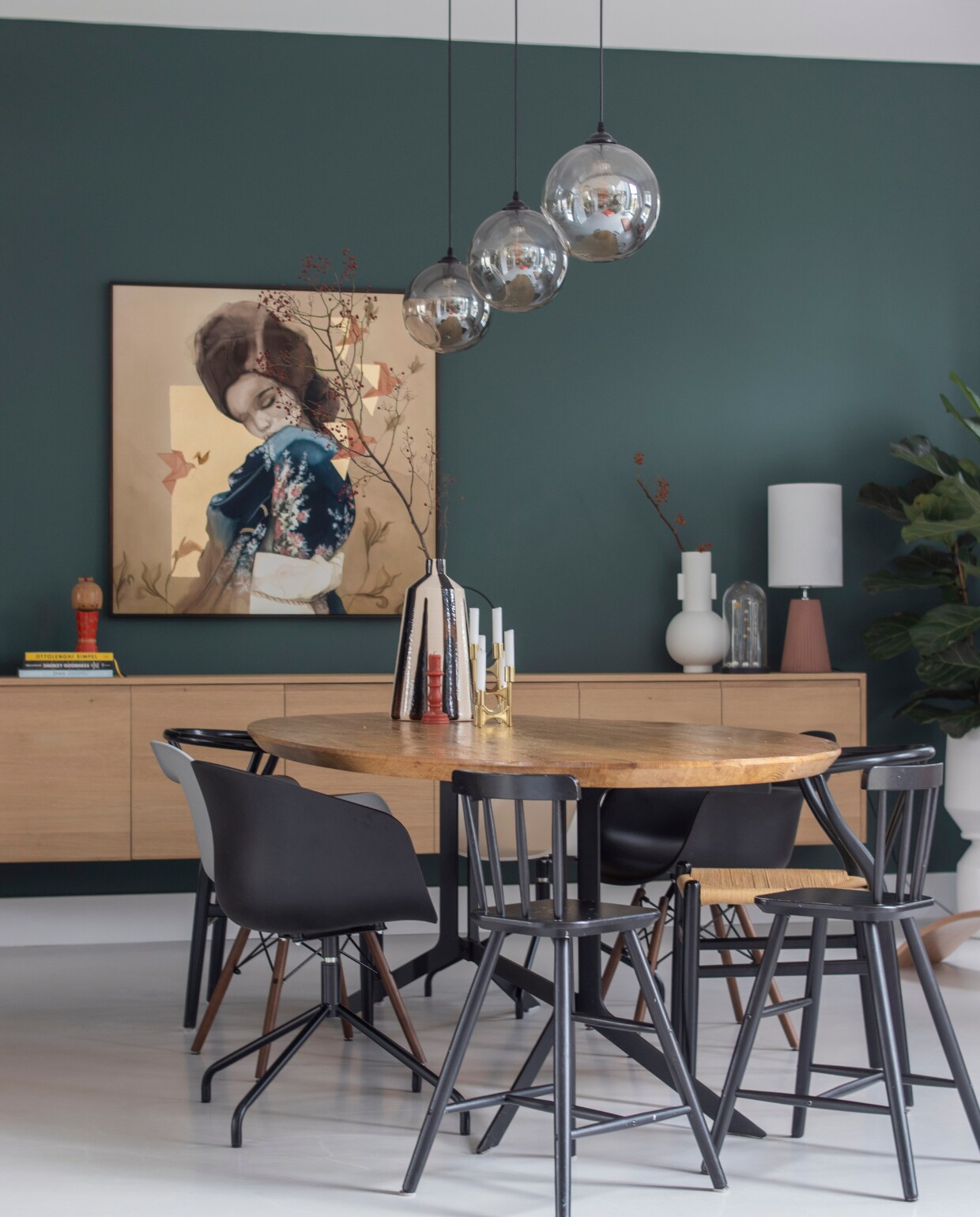 Muurverf Frivool van Histor, tafelblad Marktplaats met onderstel gemaakt door Vitriwand, rieten stoelen en boekenstandaard Loods 5, kinderstoelen Ikea, kuipstoelen Mobelaris, kunstwerk Chris Luka, hanglampen Wonenmetlef, tafellamp zelf samengesteld, dressoir gemaakt door Mh Design Meubelen, kaarsen en vaas op tafel Zara Home, witte vaas HKliving, balansbord Wobbel, kist vtwonen. Overig onbekend. NEE | vtwonen 11-2022 | Productie CocoFeatures | Fotografie Anne de Haan | Tekst Monique van der Pauw