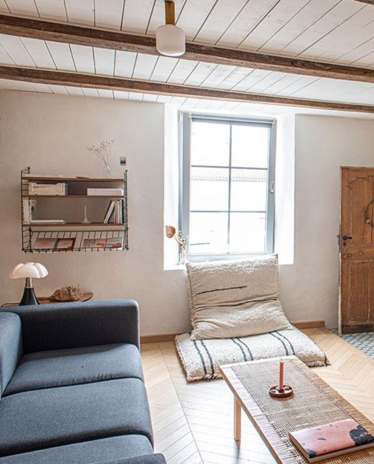 Bank Hay, fauteuil Ethnicraft, tafel Ikea, vloerlamp Ikea, wandrek String Furniture, grote vloerkussens Ar-monia (Spanje), tafellamp Pipistrello van Martinelli Luce, plafondarmaturen Zangra met peer van Tala, houtkachel Hase, kandelaar zelfgemaakt. vtwonen 3-2022 | productie De Binnenkijkers | styling Jeske Weel | fotografie Caroline Coehorst | tekst Chris Muyres