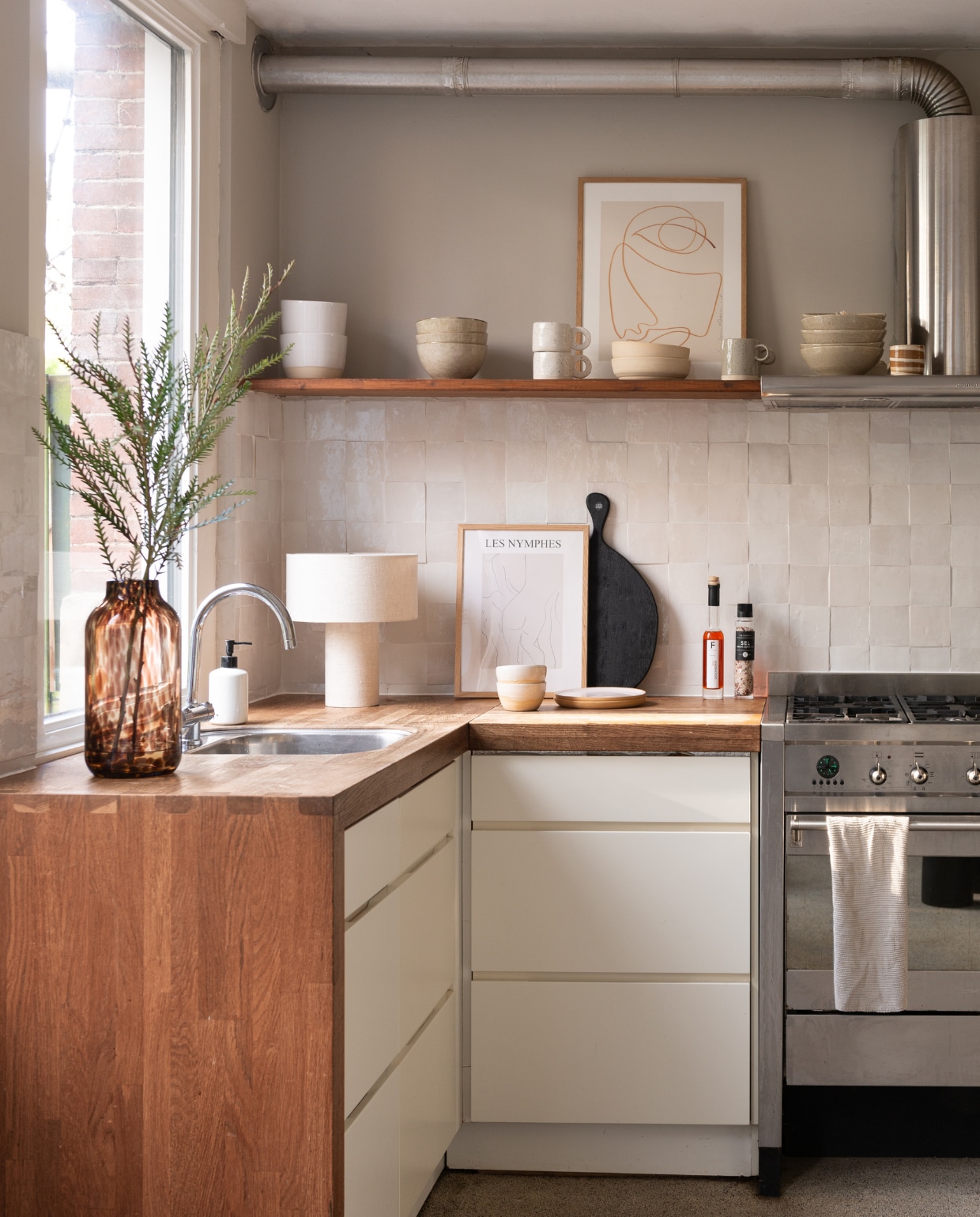 Keukentegels Mosaic Factory, wandlampen vintage, kunst op plank van Loulou Avenue, koffiezet­apparaat Ecm, keramieken servies Ghesq, bruine vaas Loods 5. Overig onbekend. productie Living Inside | fotografie Peter Dekens |