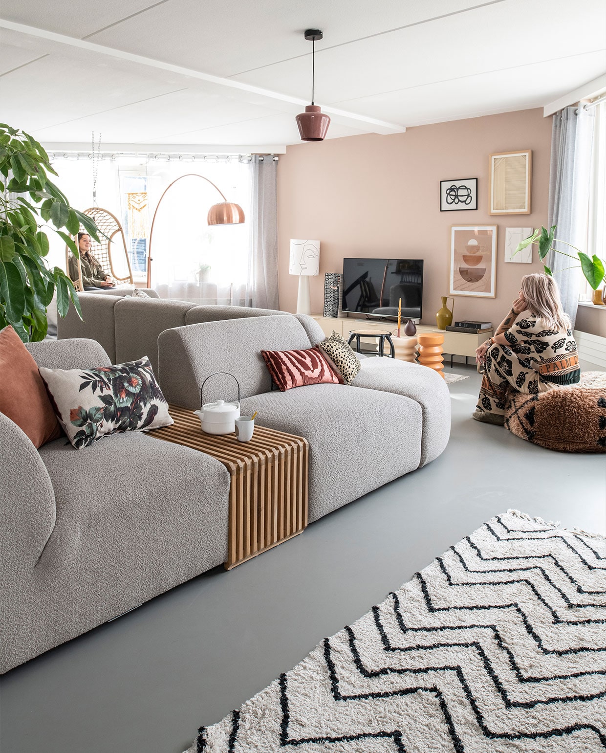 Muurkleur Zeester van Flexa, gietvloer Evolve. Bank en elementen Jax van HKliving. Theepot Home Society, beker Dassie. Kussens, hangstoel, staande lamp, dressoir, bijzettafels, rotan krantenbak en zigzagvloerkleed HKliving. Kunst op de wand: linksboven Sissy-Boy, rechtsboven HKliving, linksonder Incado, rechtsonder HKliving. Vloerkleed achter de bank en poef Aai Made With Love, booglamp Zuiver, hanglamp Woood. Kandelaar Branded, kaars Ravie, okergele plantenpot BePureHome. vtwonen 3-2022 | productie Insidehomepage | styling Esther Loonstijn | fotografie Louis Lemaire | tekst Inge Van Lieshout | tekstbewerking Mirjam Rosema-Verhulst