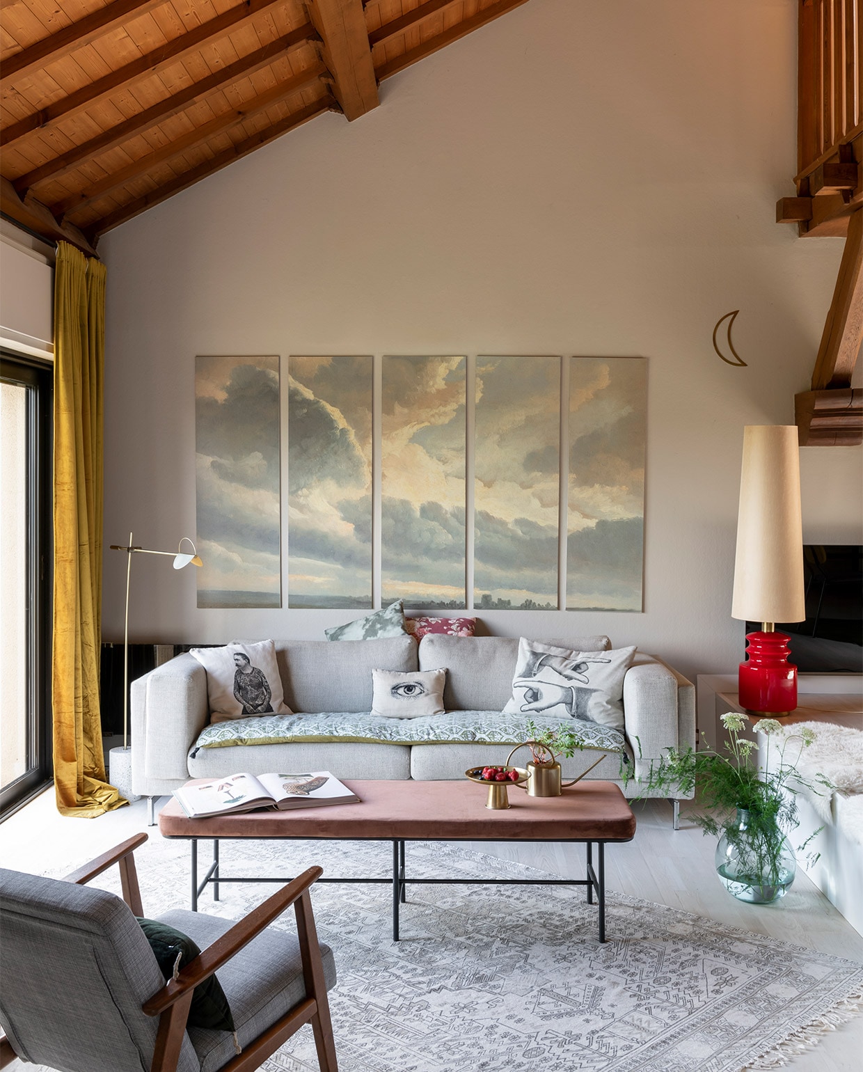 Schilderijen Sunset Clouds van Dominotiers, bank en fauteuils Ikea, salontafel House Doctor, rode lamp via La Brocante des Morues, kussens van Vanillafly, Le Monde Sauvage en Héritage Studio. Deken op bank Harmony Textile, vloerkleed HKliving, vloerlamp Bolia, gordijnen zelfgemaakt met stof van Nobilis, vachtjes Fab Design, maandecoratie Les Petits Bohemes, gieter en plateau H&amp;M Home, vaas Casa. NEE | vtwonen binnenkijken special 2021 | productie A&amp;J | fotografie Julien Fernandez