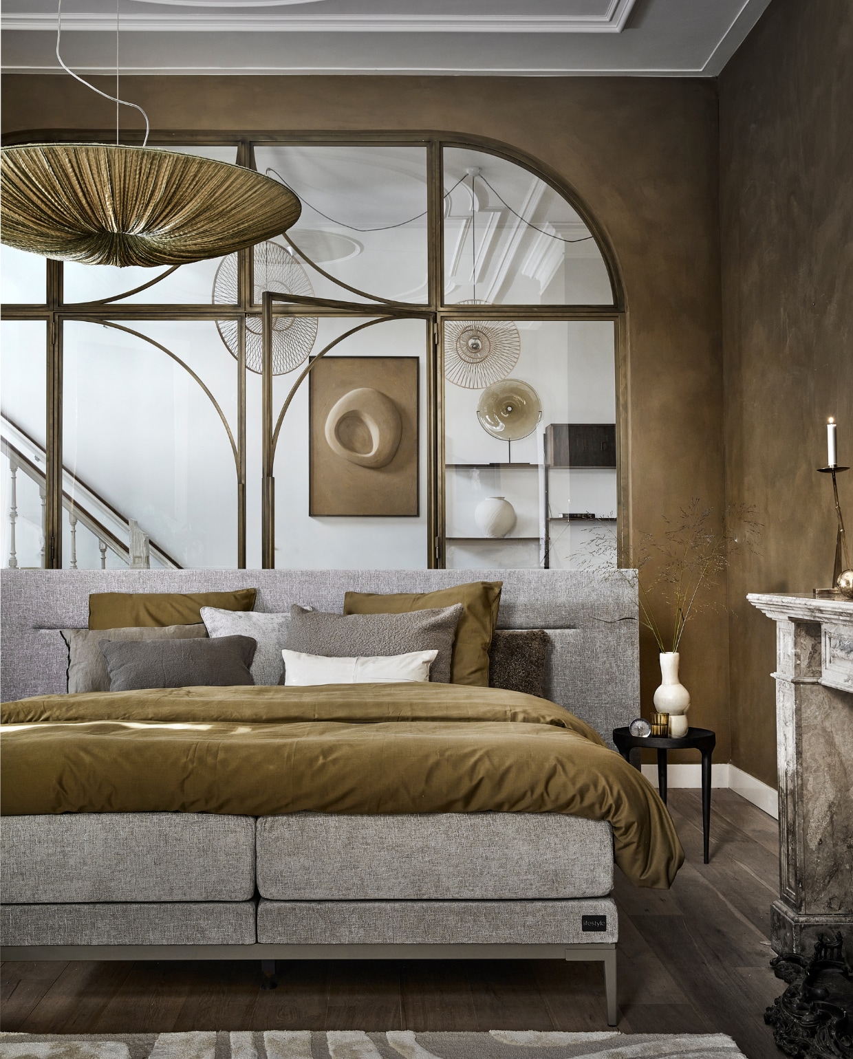 Boxspring Lifestyle by vtwonen Cinnamon Large in stof Mirage Taupe vanaf € 2090,- (140×200 cm) met champagne frame en poot Track. vtwonen 12-2022 | productie Tanja Saarberg | styling Danielle Verheul | fotografie Peggy Janssen