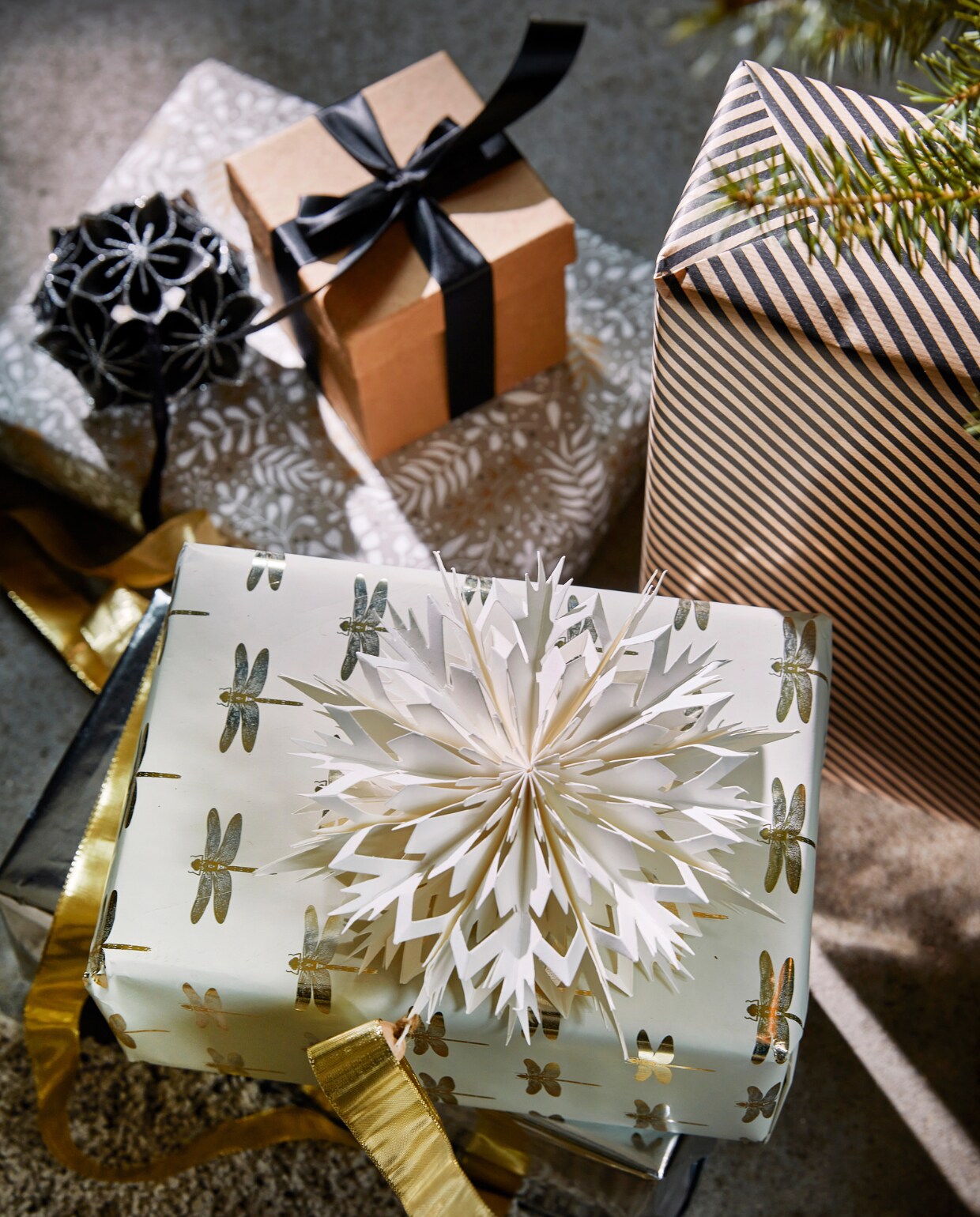 Zwart papieren ornament bloem met glitter, 10 cm (Ø) € 5,99, wit papieren ornament, 30×7 cm (Øxd) € 3,99. vtwonen 12-2022 | productie Tanja Saarberg, Isa Hoevens | styling Kim van Rossenberg | fotografie Peggy Janssen