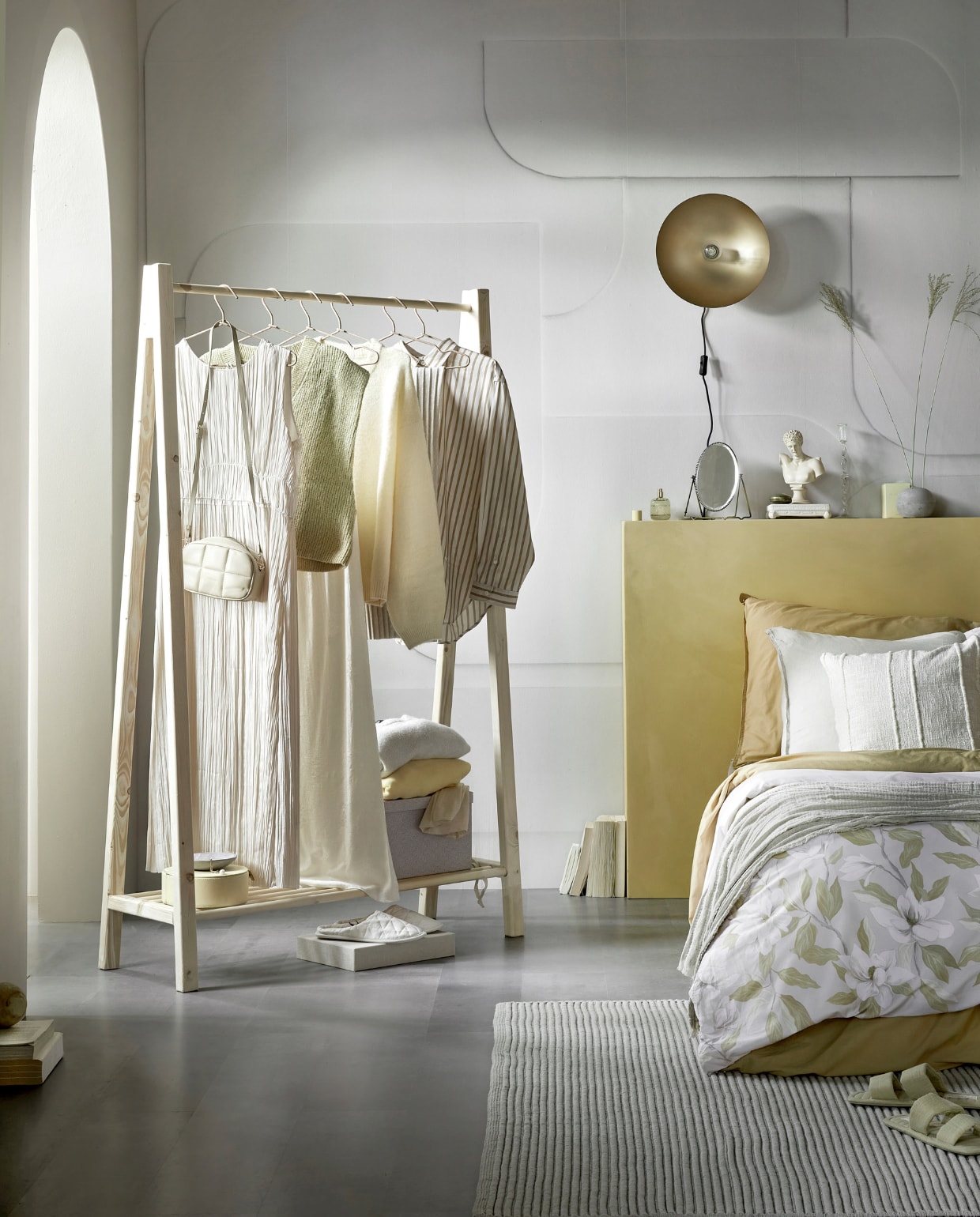 Grijze laminaatvloer Grit, lamel, 128,6×19,4×0,8 cm zonder groef, 8 lamellen per pak voor 2 m², per m² € 23,99. Fotobehang Soft 3D in Light Grey, 6 banen van 280×50 cm, totaal 280×300 cm (lxb) € 149,-, per m² € 17,74. Muurverf kleur Straw, per liter € 23,99. Metalen wandlamp Disk in antiek brons, 33×15 cm (Øxh), exclusief lichtbron € 84,99. Kunststof vloerkleed Ridge, 160×230 cm € 149,-, 200×300 cm € 249,-. Kledingrek DIY-ontwerp, kijk voor de werkbeschrijving op vtwonen.nl/diy/ vtwonen 12-2022 | productie Tanja Saarberg | styling Sanne Ketelaar | fotografie Peggy Janssen