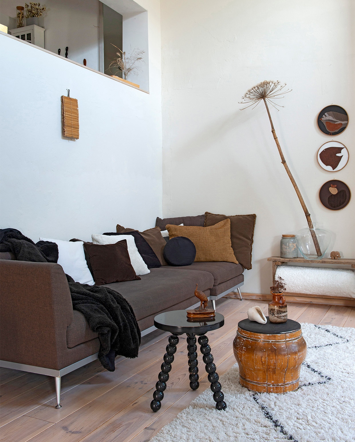 beeld vtwonen vtwonen 08-2021 | Productie de Binnenkijkers | Styling Jeske Weel | Fotografie Caroline Coehorst | Tekst Christine van der Hoff\n\nvtwonen 08-2021 | bruine bank met vloerkleed en zwarte bijzettafel