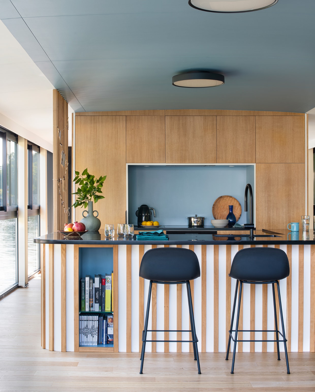 Muurverf Grey Stone en keukenblad geverfd in Black Corian van Little Greene, barkrukken Muuto, lampen LP Slim Round Louis Poulsen, vloer gelakt met Oak Natural, servetten Haomy, vaas Serax, servies Am.pm en Zara Home. Overig onbekend. vtwonen 10-2022 | styling Marie-Maud Levron| fotografie Patrick Sordoillet