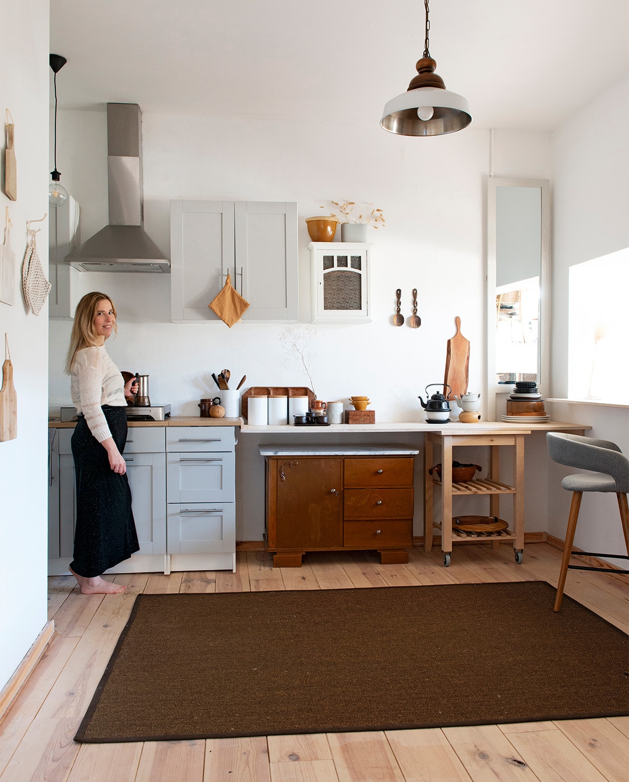 Witte voorraadbussen en zelf grijsgeverfde spiegel Xenos. Houten bar en verlengd keukenblad Woodchuck, lichtbruine lap Home by Door, droogbloemen Dreamlink via wish.com, barstoel Westwing Now, wit vaasje Edelman. Lamp vintage, samengesteld uit twee lampen, overig tweedehands van onder andere Rataplan. Herkomst vloer en sisal kleed onbekend. vtwonen 08-2021 | productie de Binnenkijkers | styling Jeske Weel | fotografie Caroline Coehorst | tekst Christine van der Hoff