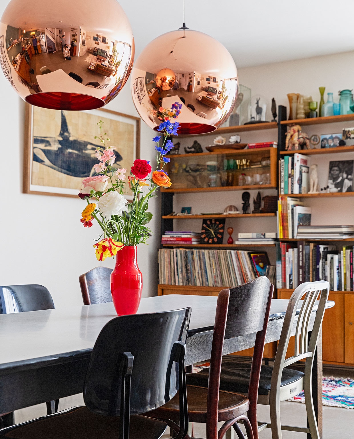 Eettafel Neef Louis Design, eetstoelen Revolt Ahrend, houten stoel erfstuk, oude politiebureaustoel rommelmarkt New York, rode vaas Hema, kunstwerk Salvor, vloer zandcement met twee componenten hoogglanslak, kleed The Souks, boekenkast DasGaaf, vazen op de kast vintage vondsten, koekoeksklok overgebleven na een fotoshoot, overige spullen in de kast herkomst onbekend. vtwonen 09-2021 | fotografie Dana van Leeuwen | styling Ilona Jongepier | tekst Cathelijne van Wingerden