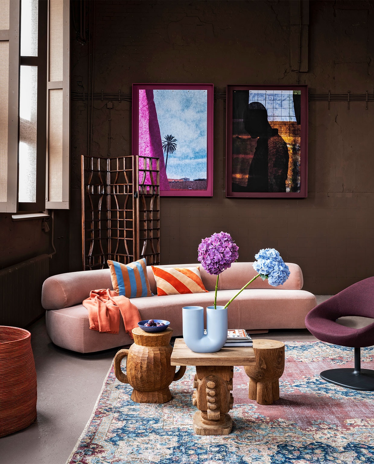 Op de muur krijtverf Brown Suga, op de vloer lakverf Rose Dust (pure-original.nl). Kunst van Tjitske van Leeuwen en Frank Visser (tjitske.com en ijm.nl). Zalmroze velours bank Gogan van Moroso, 310x128x70 cm (lxbxh) (burikenburik.nl). Fauteuil van Artifort (artifort.com). Perzisch tapijt, 395×288 cm (rozenkelim.nl). Houten krukken, mangohouten kamerscherm (polspotten.nl). Perzikroze plaid, blauw en roze gestreept kussen Hay, lavendelkleurige vaas van Muuto (eijerkamp.nl). Blauw schaaltje(hkliving.nl). Grote rode mand van olifantsgras en gerecycled plastic (basketbeadsbasics.nl). Overig privébezit. vtwonen 10-2020 | styling Marianne Luning | fotografie Stan Koolen
