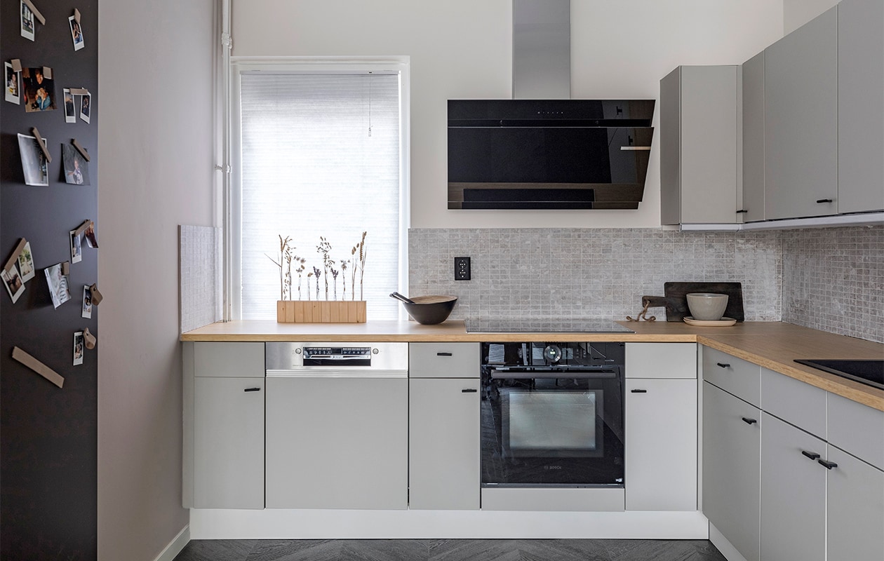 Kleur op de muur Farmers Milk, kleur op de muur Urban Taupe Flexa. Composite Mozaiek Light Grey 30×30 cm vtwonen by Douglas &amp; Jones. Plafondspot, serveerplank, bowl Nibbes en schaal bamboe zwart van Trendhopper Eijerkamp. Radiator van Vasco in de kleur Brown Grey N507 Sanitairwinkel. Keukenblad uit massief geperst bamboe Kosa Bamboo. Kastjes gewrapt met de kleur C814 Stickermaster. Keukenknoppen zwart Alle Greepjes. Inductiekookplaat PVS775FC5E, afzuigkap DWK67CM65, compacte magnetron met hetelucht CMA485GS0, vaatwasser SMI4HCS48E, besteklade Bosch. Kraan CA106BK, spoelbak CAGR50KRBK-TU Caressi. Wandbord zwart Handles and more. Plant Bloemenweelde Amsterdam. Overig privébezit. vtwonen weer verliefd op je huis, seizoen 14 aflevering 4 | styling Eva van de Ven | fotografie Margriet Hoekstra