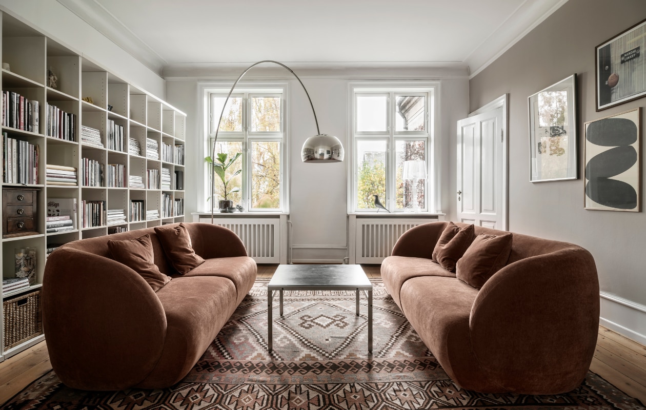 Bank Paula van Sofacompany, vintage kelim vloerkleed jaren geleden gekocht, salontafel gemaakt door Line’s vader, vloerlamp Flos Arco, boekenkast Ikea, vierentwintig jaar oud. Kunst aan de muur met de klok mee: zwart-witte litho gekocht bij Gallery Op Ad Trappen Kopenhagen, foto van fotograaf Pernille Enoch, grafisch werk Nina Bruun voor Paper Collective. vtwonen 11-2022 | Productie Global Image | Fotografie Peter Kragballen