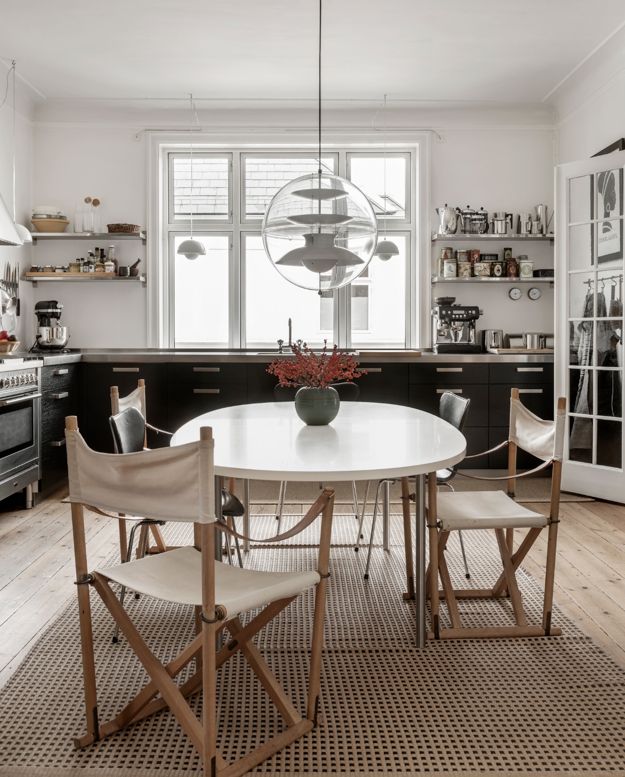 Ronde tafel Marianne Wegner, twee Series 7 stoelen van Arne Jacobsen, drie vouwstoelen van Mogens Koch, hanglamp Globe van Verner Panton, ruim twintig jaar oud papiergaren vloerkleed van Woodnotes. Overig onbekend. vtwonen 11-2022 | productie Global Image | fotografie Peter Kragballen