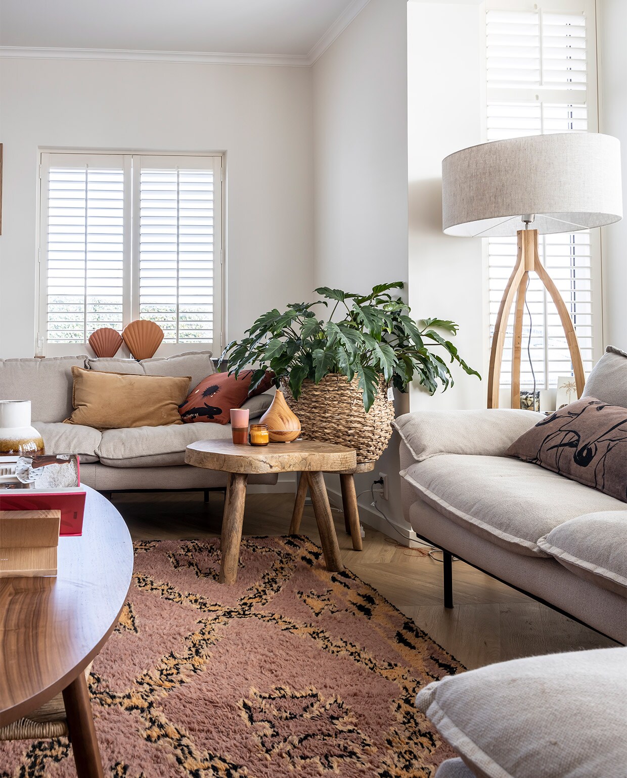 Lijsten Desenio, foto’s Profotonet, banken, kussens, schelpenvazen, vloerkleed, plaid en kruk HKliving. Salontafel Ikea Stockholm-lijn, vaas op tafel Zara Home, lamp It’s About Romi. Boekenstandaard onbekend, mand tuincentrum, mok HKliving, diffuser Geurwolkje. Shutters Veneta. vtwonen binnenkijken special 12-2021 | fotografie Henny van Belkom