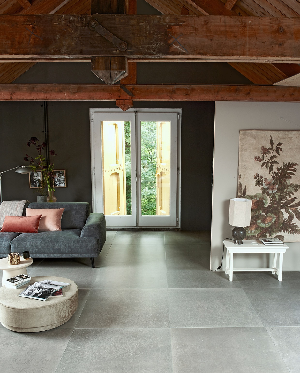 Vloertegel concrete taupe uit vtwonen huiscollectie: 70×70 cm per m² € 56,50, ook verkrijgbaar in de kleuren Antracite en Black. M.m.v. vtwonen.nl (bank, poef) hkliving.nl (tafeltje, lamp, wanddecoratie, vaas, theepot), loods5.nl (kommetje, houten lijsten). Verf op muur vtwonen Warm Grey vtwonen 10-2019 | styling Fietje Bruijn | fotografie Dennis Brandsma