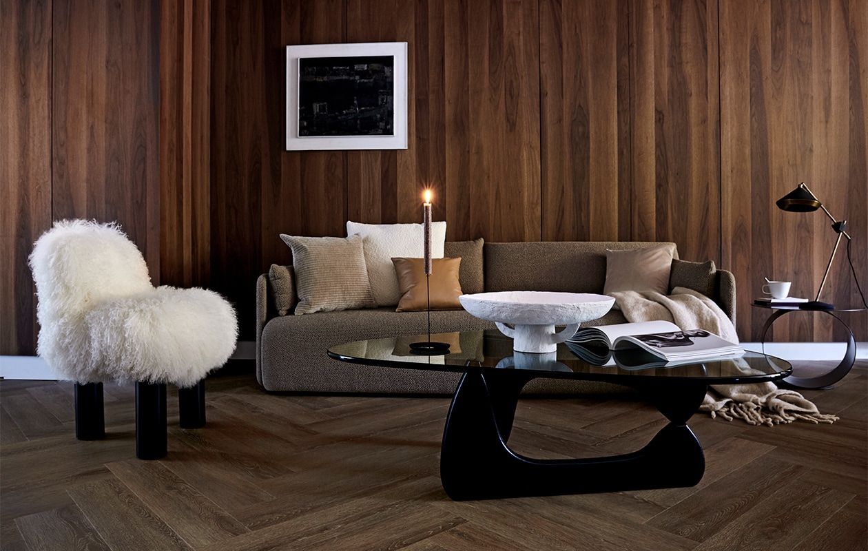 Vloer uit de vtwonen collectie: PVC Vloer Herringbone Roasted, 76,5×15,3 cm per m² € 44,95 / € 57,95 (resp. dryback-systeem / click-systeem), ook in kleuren Natural, Sun Kissed en Polar.M.m.v. designtales.nl (bank), covanderhorst.nl (salontafel, fauteuil, bouclé kussen, velours kussen, tafellamp), kasstoor.nl (bijzettafel rond), klevering.nl (witte schaal, kandelaar, mok), bolia.com (velours kussen, leren kussen), loods5.nl (plaid), cocoon-living.nl (kunst). Overig privébezit. vtwonen 10-2020 | styling Danielle Verheul | fotografie Petra Steenkamer