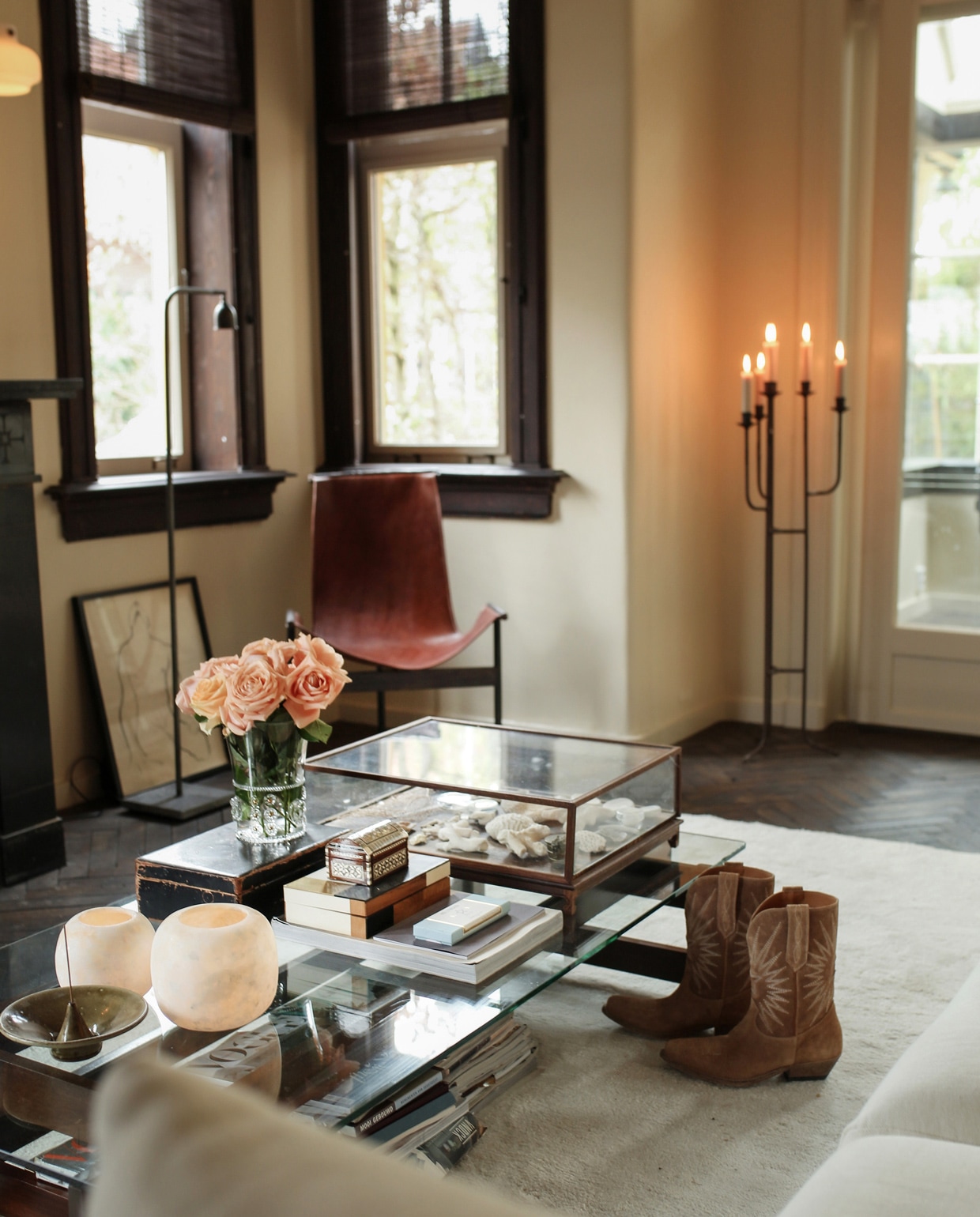 Leren fauteuil en vloerlamp Brecht Murré Atelier. Salontafel met vitrinekast vol natuurvondsten in het buitenland gekocht. Bank l’Authentique, op maat gemaakt vloerkleed Cunera, kaarsenkandelaar tweedehands. Stolp Pols Potten. Overige op tafel kringloopwinkel. vtwonen 09-2021 | Styling Liza Wassenaar | Fotografie Irisdorine |