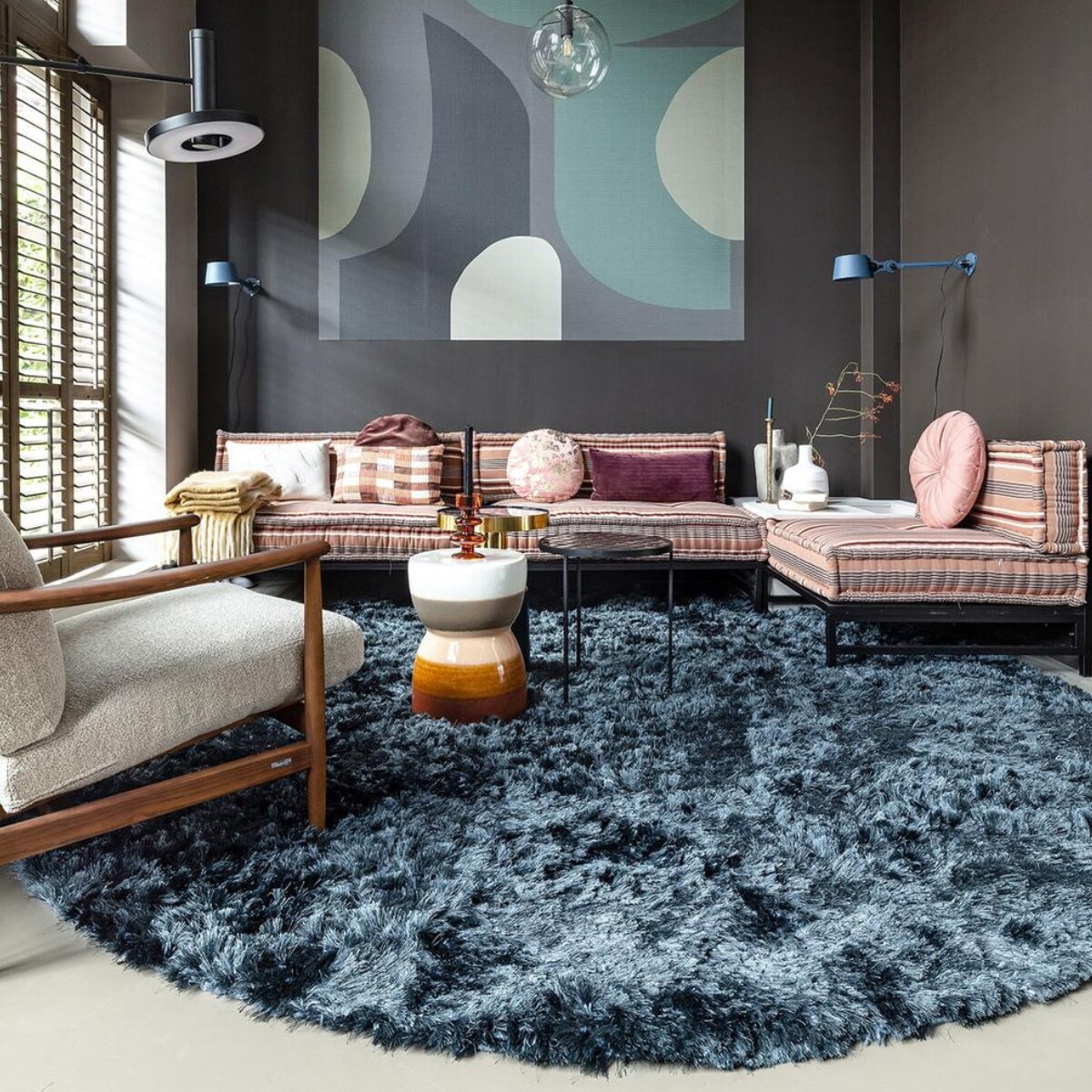 Paneel met behang Atlantis Aube van Christian Lacroix voor Designers Guild, 300×350 cm € 927,- (wva.nl). Blauwe muurverf Exciting Night No. 96 van Lab Paint, per liter € 45,- (vestingh.nl). Groene velours bank van Arflex, 96x354x70 cm (dxbxh) € 5709,-, roze fauteuil van Warm Nordic, 95x84x80 cm (lxbxh) € 2190,-, zachtroze hoogpolig wollen vloerkleed van Layered, 250×350 cm € 1090,- (goeds.nl). Multikleurige voetstoel in stof Rayure Chinoise Alchemilla van Designers Guild, 90×90 cm € 1485,-, oorfauteuil Harper Chair bekleed met stoffen van Christian Lacroix voor Designers Guild € 3220,- (wva.nl). Verstelbare vloerlamp € 659,- (hay.nl). Roze staaldraad tafel van Bold Monkey, 41x41x40 cm (lxbxh) € 165,- (boldmonkey.com). Kandelaars vanaf € 14,50, kaarsen van Hay, per 6 € 25,- (vtwonen.nl). Glazen vaas € 85,- (hay.nl). Vintage bord € 25,- (hetgroteavontuur.nl). Blauwe gaasschaal € 39,- (festamsterdam.com). Kussens van links naar rechts: rood geborduurd € 149,-, langwerpig model van zijde, per stuk € 89,- met bloemdessin € 109,-, groen geborduurd € 149,-, alles van Lelievre (loggerewilpower.com), velours streep van William Yeoward € 121,-, bloemen Christian Lacroix voor Designers Guild € 192,-, geborduurd € 132,-, wollen plaid van Designers Guild € 327,- (wva.nl).