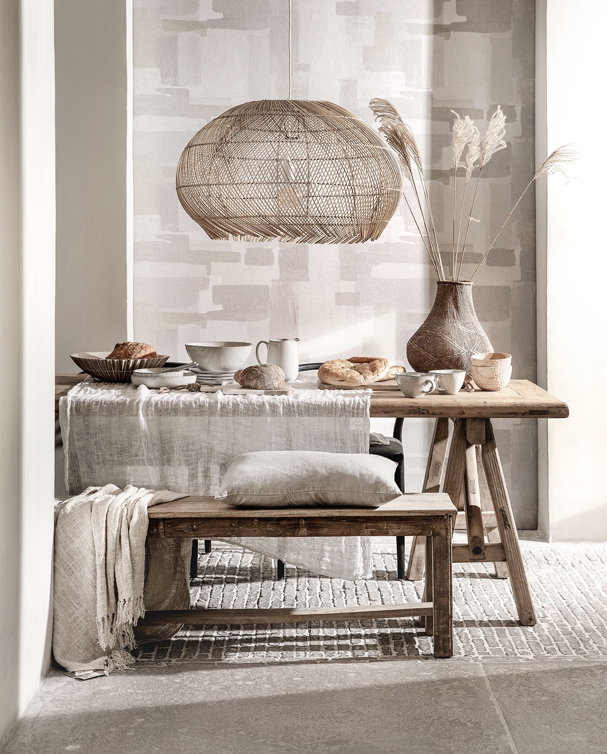 Behang Lino, 106 cm breed per meter € 15,95 (eijffinger.com). Rieten hanglamp € 229,95 (manggisliving.nl). Houten whitewash schaal Marseille € 92,50 (mrsbloom.nl). Servies Broste Copenhagen; schalen v.a. € 19,95, grote schaal € 39,95, kan € 33,95, bord € 11,95, grote kom met oor € 15,95, bewerkte houten schaaltjes per stuk € 39,95 (loftloft.nl). Linnen kussen € 49,95, eettafel van oud hout, 260×90 cm € 1795,-, oud teakhouten bank 176 cm breed € 245,- (hetkabinet.nl). Grof geweven plaid € 87,95 (heinshome.nl). Vaas € 69,- (stylexclusief.nl). vtwonen special 03-2019 | styling Moniek Visser | fotografie Peggy Janssen