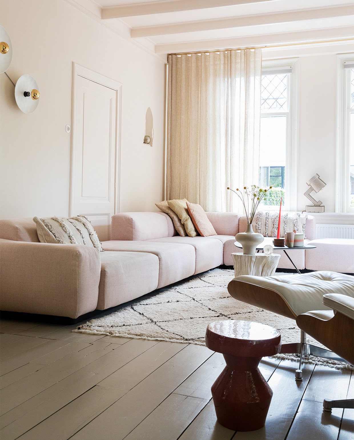 Bank Soft modular van Jasper Morrison en stoel Eames via Vitra. Vloerkleed en kussens links en rechts Household Hardware. Kussens midden Blooming Interior. Witte bijzettafel en vaas van Pols Potten via Wim van Assem bloembinderij. Zwarte bijzettafel Leolux en bijzettafel voorgrond via Eijerkamp.Wanden, deur, plafond kleur Julie’s Dream van Little Greene. Vloer kleur Brown Wood van Vestingh Paint. Papier-maché lamp Tradition via Loods 5. Gordijnen Van den Bosch Interieurstoffen. Messing railroede Corpus van Interstil. Presse papier Hafod Grange. Wandlampen vtwonen. Theebeker en koektrommel HKliving. Onderzetters Ikea. Kaars Ester &amp; Erik. JA | vtwonen 02-2022 | styling Ilona Jongepier | fotografie Dana van Leeuwen