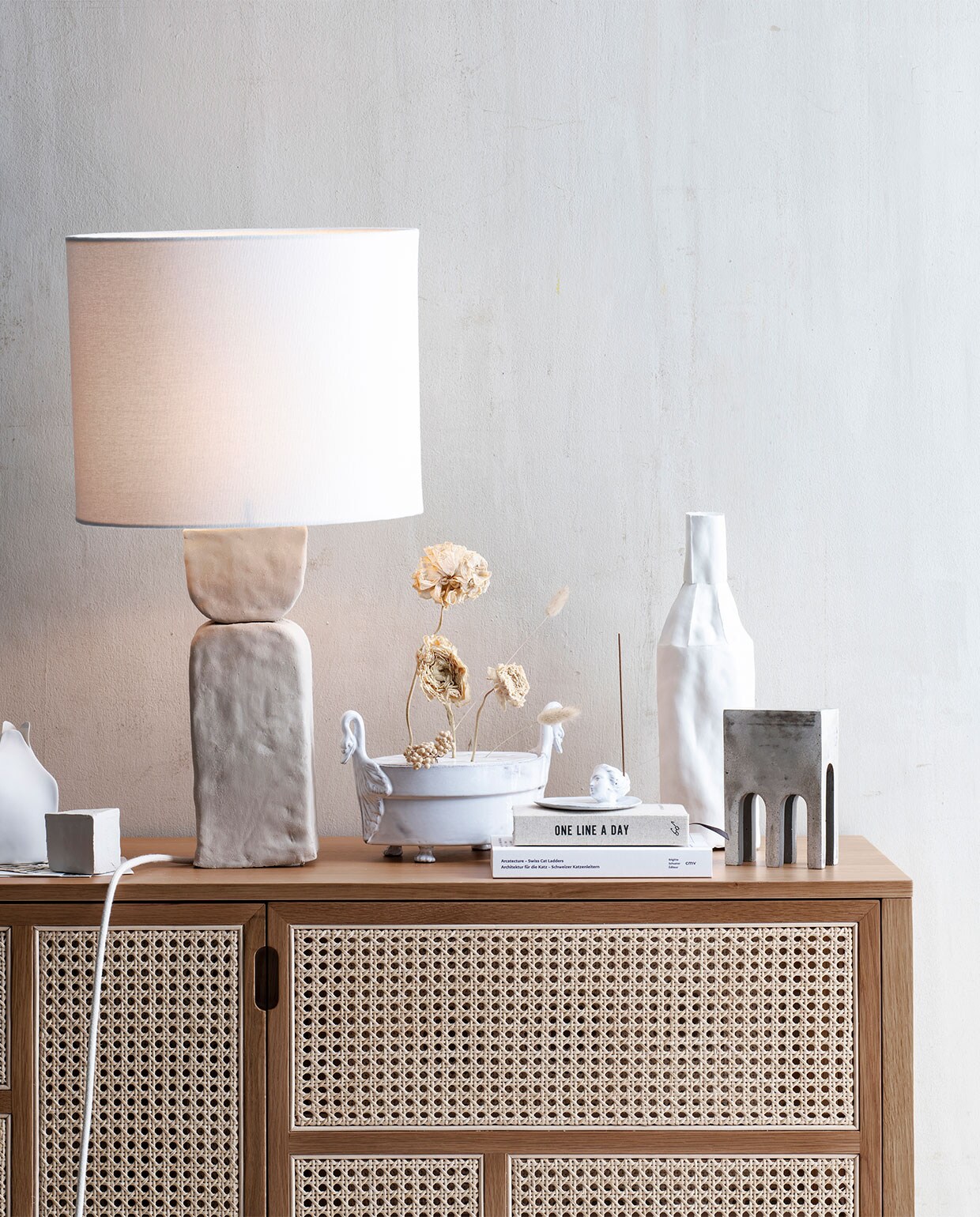 Lampenvoet uit vtwonen DIY Snoer per meter € 4,20, fittingringen per stuk € 0,65, fitting met buitendraad € 1,75, lamp € 5,99, stekker € 1,75, draadeinde per meter € 4,89 (snoerboer.nl). Lamp waarvan kap is gebruikt € 89,99 (zarahome.com). Kast € 1858,-, witte hoge vaas € 175,-, (edha-interieur.nl). Vaas links € 11,50, (bijenkorf.nl). Kaart pak van 8 € 24,95 (sukha.nl). Droogtakjes prijs op aanvraag (tuinvanjudith.wordpress.com). Vaas met zwanenkopjes € 329,-, wierookhouder € 69,-, wierook € 35,-, boek One line a day €19,95 (maisonnl.com). Boek onderop € 40,-, grijze siervorm € 145,- (frozenfountain.nl). Overig privébezit. vtwonen 08-2020 | styling Liza Wassenaar | Louis Lemaire