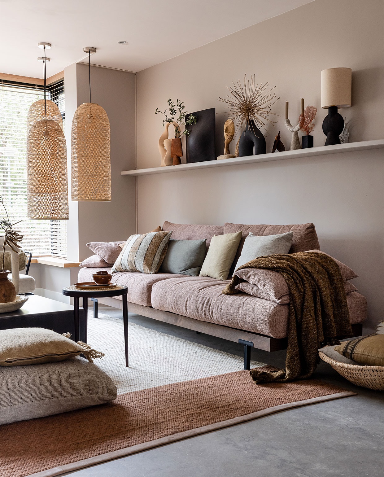 Flexa Creations muurverf Urban Taupe, plank DIY (info@bminterieurmakers.nl) in kleur Urban Taupe (flexa.nl). Raambekleding prijs op aanvraag, pvc-vloer betonlook Dynamic Cemento 609 met plint (woninginrichting-aanhuis.nl). Hanglampen Cap Natural per stuk € 570,- (ayilluminate.com). Bank Pacha van Eijerkamp Collectie € 2925,-, gevlochten mand naast bank Urban Nature Culture € 84,-, kussen Linen Dark in mand HKliving € 29,95, salontafel Industry van Feelings € 299,-, bijzettafel Hako van 101 Copenhagen € 352,-, vloerkleed Red Chain van Label € 2405,-, groot kussen op grond Mayla € 167,-, zandkleurig kussen Kelim Fringe Ferm Living € 75,- (eijerkamp.nl). Op plank boven bank van links naar rechts: sculptuur Bloomingville € 84,99 (nordicnest.nl), vaas Sphere Vase 101 Copenhagen € 59,-, vaas Origami Vase Big Coffee € 179,- (eijerkamp.nl), ornament Deco Gezicht Bloomingville € 64,90 (vtwonen.nl), handgeweven waaier € 36,- (couleurlocale.eu), zwarte vaas met twee poten € 34,99 (hm.com), houten vogel van Gazzda € 75,- (eijerkamp.nl), stenen kandelaar met twee armen € 70,- (nordal.eu), decoratievorm op zwarte voet, vanaf € 99,- (violierathome.nl), tafellamp Bloomingville € 115,- (vtwonen.nl). Effen kussens op bank vanaf € 39,- (bymolle.com). Kussen met streep House Doctor € 52,-, plaid The s’il vous Plaid Brown € 129,95 (eijerkamp.nl). Op salontafel papier-maché schaal van Lightmakers € 34,99 (eijerkamp.nl). Vaas Tamegroute Natural Vase Jerrycan € 115,- (householdhardware.nl). Houten vaas van New Routz € 54,95 (vtwonen.nl). Op bijzettafel bord € 18,70 en kom van Urban Nature Culture € 10,95 (vtwonen.nl). Lepels op bord New Edition HomeSalad Servers, set van twee € 12,95 en € 14,95 (eijerkamp.nl). Planten en droogbloemen (plantje.nl). vtwonen weer verliefd op je huis | seizoen 15, aflevering 7 | styling Liza Wassenaar | fotografie Sonja Velda