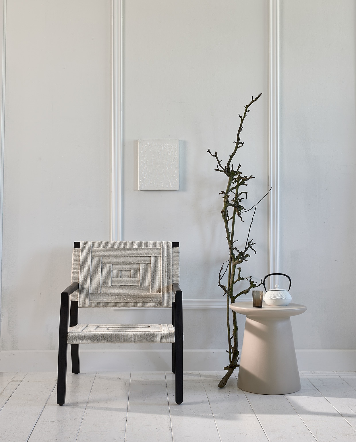 Stoel met gevlochten singels Shima (eijerkamp.nl). Keramische tafel (hkliving.nl). Japanse theepot, grijs geribbeld glas, (loods5.nl). Kunst prijs op aanvraag (atolty.com). Lijsten via bouwmarkt. vtwonen 10-2020 | styling Fietje Bruijn | fotografie Dennis Brandsma