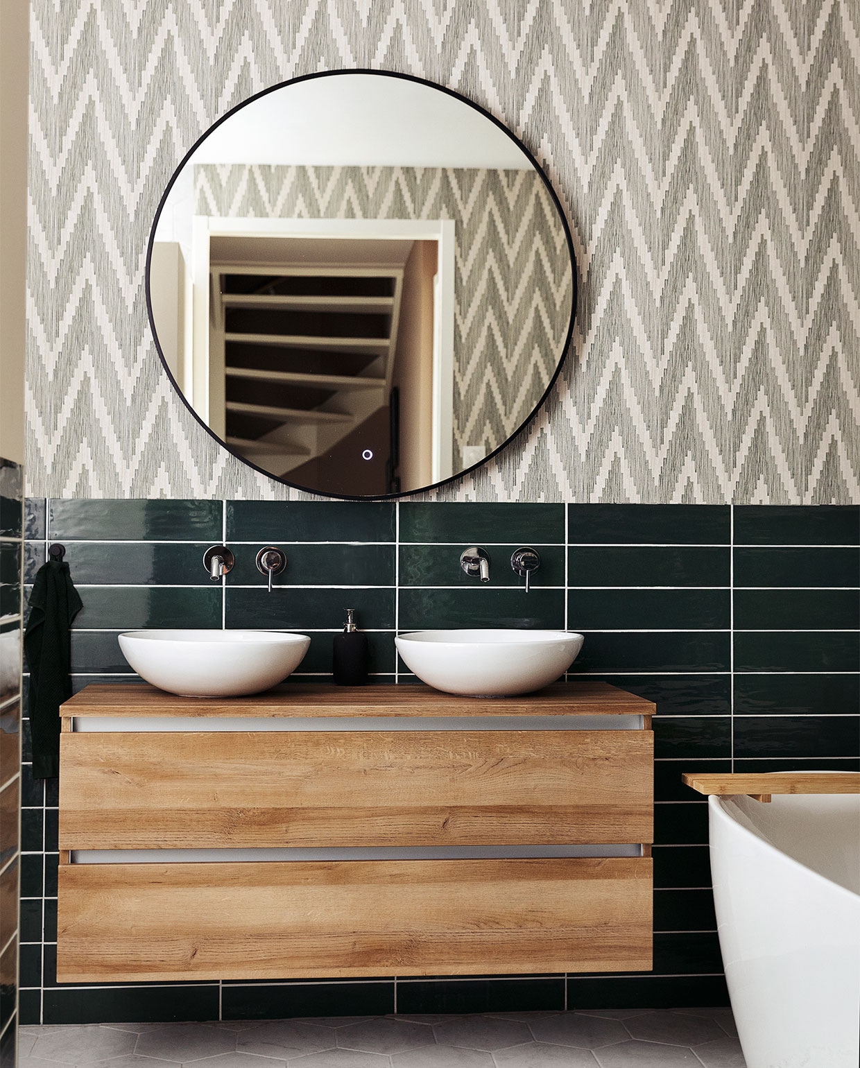 Badkamerkast Unihopper. Wastafelkommen Solid Surface. Kranen en vrijstaand bad ADW. Spiegel Best Design. Tegels Sartoria. Behang BN Walls. Kleed H&amp;M Home. JA | vtwonen 10-2021 | styling Ilona Jongepier  | fotografie Dana van Leeuwen