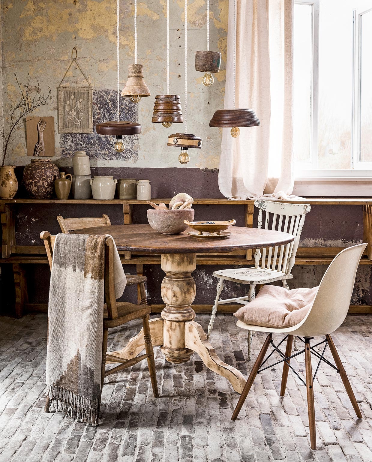 Vintage woonkamer, , Schaaltjes vanaf € 1,-, kunstwerkje met touw € 0,50 (Kringloop Op Dreef). Linnen strijkijzersnoer € 6,25 per meter, fitting van zwart bakeliet € 1,45, kooldraadpeer dimbaar € 12,95 (Snoerboer). Tafelpoot geschuurd € 60,-(Kringloop ’t Zwaantje). Stenen schaal € 42,50, gevlekte karaf € 65,- (Raw Materials). Fruitschaal/zeef € 17,50, kleine karaf € 9,50, wekpotten vanaf € 8,- (Linda’s Hoekje). Vergeten groente (Albert Heijn). Stoel Eames € 395,- (La Folie). Kussen € 69,95, gordijn gemaakt van linnen stof 160×260 cm € 119,- (By Mölle via www.vtwonen.nl). Houten stoelen € 25,-, twee houten bankjes op elkaar gestapeld als kast € 15,-, grote karaf (met tak) € 15,- (Van Dijk &amp; Ko). Witte spijlenstoel € 179,- (www.vtwonen.nl). Sjaal op stoel € 208,- (Sukha Amsterdam). Kunstwerkje handen € 100,- (Julia Lefeber). Overig privébezit. vtwonen 06-2017 | styling Liza Wassenaar | fotografie Sjoerd Eickmans