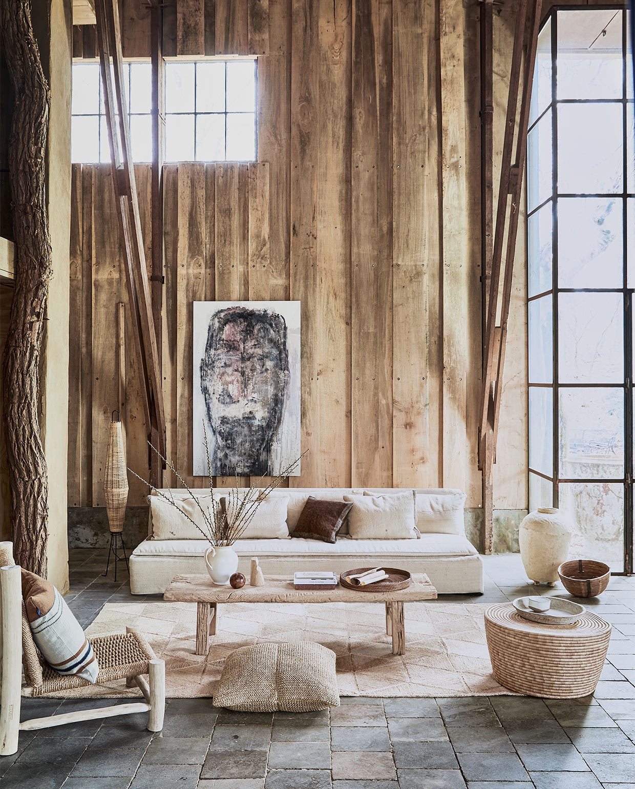 Landelijke woonkamer , , Ovale bijzettafel Cone van palmbladeren, 40×70 cm (hxØ) € 430,-, rotan vloerlamp Naasha € 580,-, stoel van sisaltouw en hout, 90x76x80 cm (hxbxd) € 485,-, salontafel van olmhout, 180x66x40 cm (lxbxh) € 1250,-, juten mat Sunda, 318×200 cm € 1199,-, vintage papier-maché graanpot € 640,-, kussen van geknoopt sisal, 65×65 cm € 330,-, gestreept kussen, 63×63 cm € 123,-, bruine zeegras schaal € 95,- (couleur-locale.eu). Schilderij, 100×200 cm prijs op aanvraag (martvisser.nl). Bank en kussens gemaakt van vintage linnen lappen, 300×90 cm prijs op aanvraag (mvninteriors.com). Kan € 39,99 (zarahome.com). Papier-maché dienblad € 35,-, rieten mand € 40,- (weldaad.com). Marmeren object Shoulder van Cooee Design € 149,- (nordicnest.nl), kom op dienblad Merci n°1 van Serax, 12,5 cm (Ø) € 15,95 (vtwonen.nl). Overig privébezit vtwonen 05-2021 | styling Cleo Scheulderman | fotografie Jeroen van der Spek