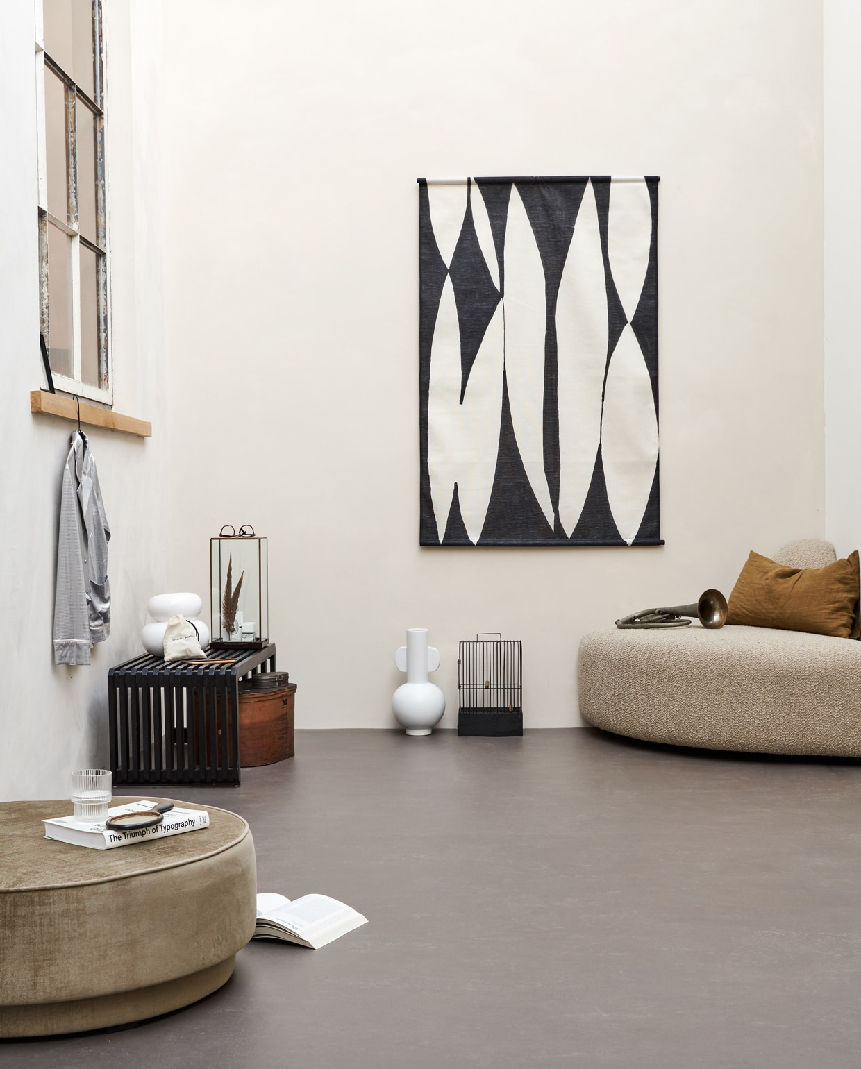 Basic woonkamer, , M.m.v. hkliving.nl (halfronde sofa, doek aan de wand, witte vaas met oren, zwarte bank, stolp van glas en hout), pantoufle-design.nl (linnen kussensloop), jolandelijkdewebshop.nl (handspiegel, vogelkooi, trompet, houten hoedendoos), vtwonen.nl (ronde poef, witte vaas met bubbels). Overig privébezit. vtwonen 01-2022 | productie Tanja Saarberg | styling Marlies Does | fotografie Bart Brussee | assistentie Judie Jonker