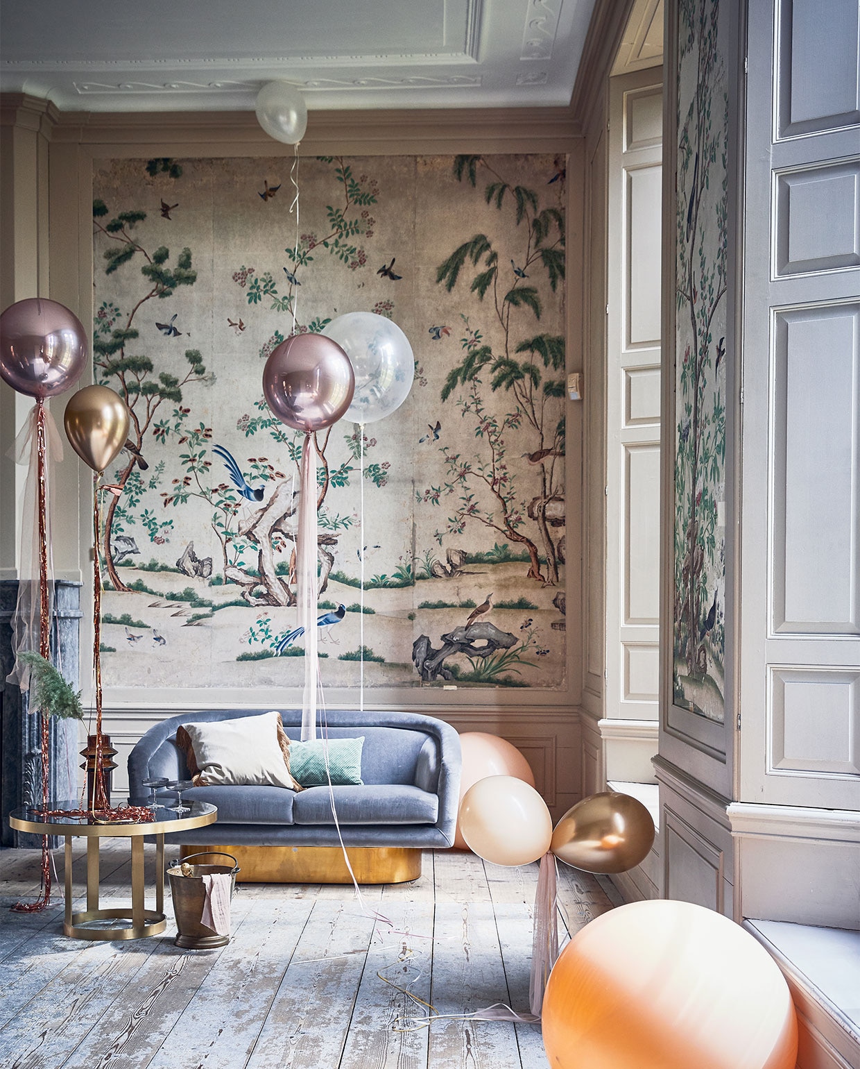 Klassieke woonkamer, Ballonnen prijs op aanvraag (partyballoon.nl). Tule per meter € 5,- (boerenbonthal.nl). Franjegordijn € 9,95 (slinger.nl). Glazen salontafel 45×80 cm € 578,-, vaas € 42,50, fluwelen kussen met franjes € 46,20 (nordal.eu). Groen kussen € 34,95, grijze champagneglazen met ribbel van Ferm Living per 2 € 39,- (vtwonen.nl). Zilvergrijze fluwelen bank van Jonathan Adler vanaf € 3545,- (ankevangoor.com). Champagnekoeler prijs op aanvraag (iblaursen.dk). vtwonen special 10-2019 | styling Cleo Scheulderman | fotografie Jeroen van der Spek