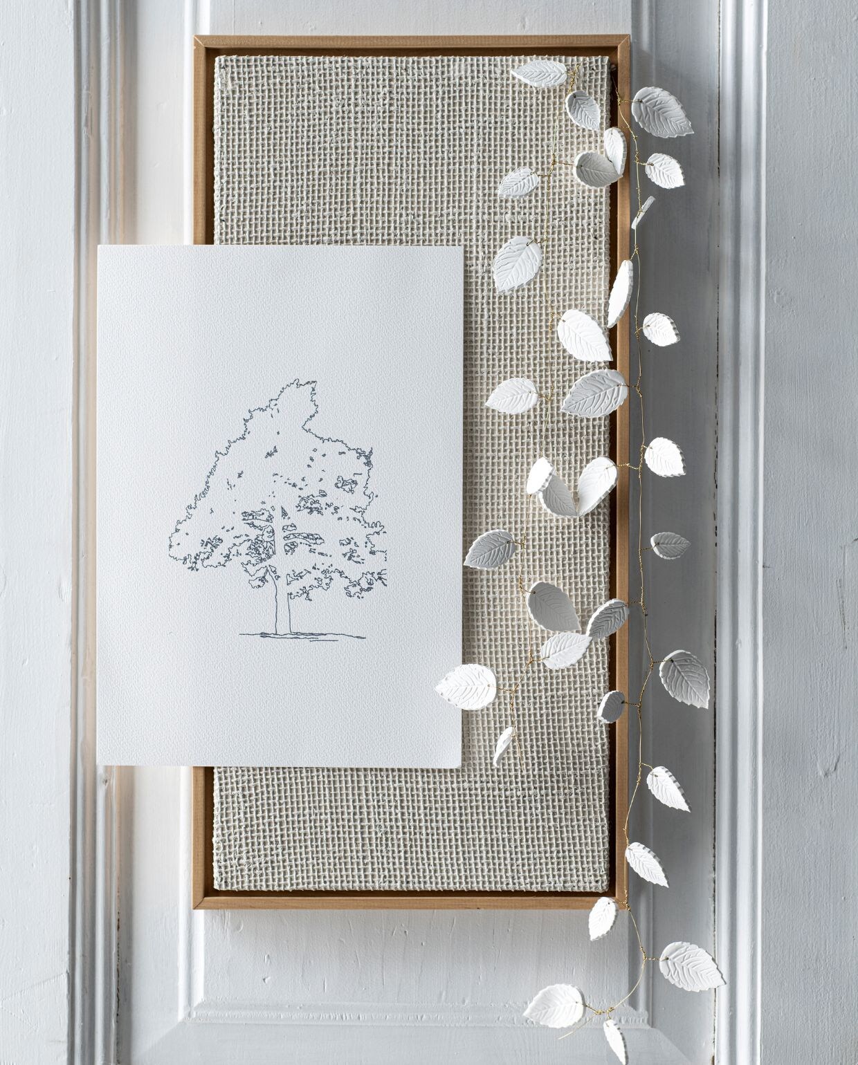 Effen juten doek met structuur en houten lijst 25×50 cm € 49,99 (zarahome.com). Handgemaakte mini vaas van Charlaine Larissa € 18 (zaanschfaamwebshop.nl. Messing kapstokhaak € 3,99 (onlinedeurbeslagshop.nl). Katoenen zak € 2,75 (natuurproduct.com). Illustratie uit oud vtwonen boek. vtwonen 09-2022 | styling Myla Griese | fotografie Louis Lemaire