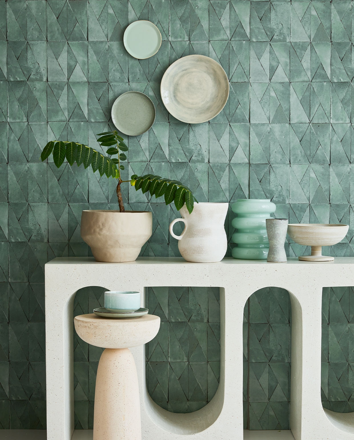 Behang Yazga in Pierre de Jade Ast nt 034 04, 100×70 cm per rol € 244,- (astere.fr). Microcement sidetable vanaf € 1850,- (lanena-home.com). Groot groen bord op de muur Wonki Ware, 30 cm (Ø) € 34,- (couleurlocale.eu). Klein mintgroen bord uit Goodmorning-collectie van Urban Nature Culture € 16,20 (vtwonen.nl). Groen bord linksonder € 6,50 (zarahome.com). Witte kan met oor € 59,95, schaal op voet € 59,95, mintgroene glazen vaas € 21,95 (urbannatureculture.nl). Mintgroene kom Munch € 45,- (groenenakker.nl). Bijzettafel € 650,- (edha-interieur.nl). Overig privébezit. JA | vtwonen 04-2022 | Styling Cleo Scheulderman | Fotografie Jeroen van der Spek | Assistentie Krystel-Jane Robinson, Jamaine Festen