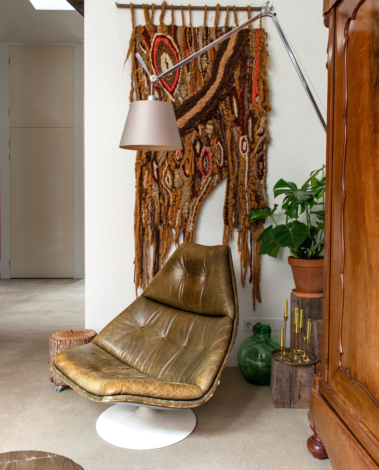 Lamp Tolomeo van Artemide, vintage fauteuil van Pierre Paulin voor Artifort, vintage wandkleed via Marktplaats, Hollandse mahoniehouten kuifkast van een tante, flesvaas en kandelaars uit Frankrijk. vtwonen 10-2022 | productie De Binnenkijkers | styling Jeske Weel | fotografie Caroline Coehorst