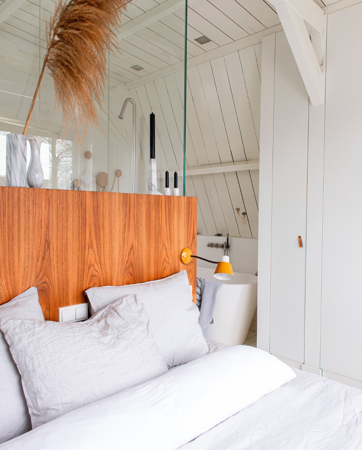 Pluim Miss Bloem, spots Nimbus, vintage marmeren kandelaars en vazen via Sprinkel + Hop, achterwand bed zelfgemaakt, linnen beddengoed van H&m Home, bedlamp vintage, al het houtwerk is geschilderd in RAL 9010. vtwonen 10-2022 | productie De Binnenkijkers | styling Jeske Weel | fotografie Caroline Coehorst