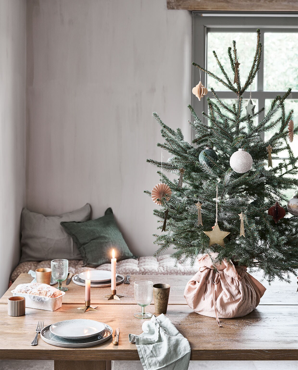 In de boom: papieren waaier € 1,49, groene bal € 2,99, bal met sneeuw € 2,49, groene ster € 1,99, honeycomb ornament € 2,79 (intratuin.nl). Messing vallende sterren € 3,50 (weldaad.com). Grote messing ster van Madam Stoltz € 7,- (deens.nl). Op tafel: servet € 2,38 (sostrenegrene.com), waxinelichthouder € 3,29 (intratuin.nl). Messing beker € 19,95, kandelaar in stervorm € 3,95 (weldaad.com). Groen wijnglas van Nordal € 11,50 (deens.nl). Zitkussen Nisha rose 50×155 cm (lxb) € 95,-, groen kussen van Bungalow 50×50 cm € 61,- (scandicliving.nl). Zachtgroene kussensloop 50×60 cm € 39,95 (yumeko.nl). Overig privébezit. vtwonen 12-2020 | styling Marlies Does | fotografie Bart Brussee