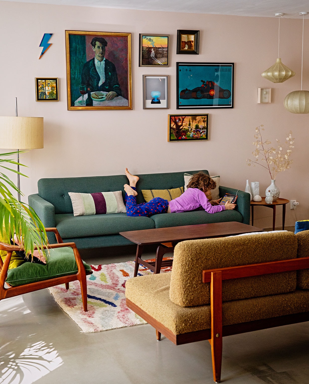 Muurverf kleur Versmelting Histor, vloer zandcement met twee componenten hoogglanslak, groene bank Sofacompany, kussens van links naar rechts HK Living, House Doctor, Michele Varian, kleed Living Maroc, salontafel Louis van Teeffelen, bijzettafel, staande lamp, hanglampen Histoire Magasin. Vazen vintage vondsten en Pols Potten. Bank zonder leuning kringloopwinkel. Kunstwerken: Bliksem van de David Bowie-expositie in Groningen, zelfportret Nicolaas Wijnberg, foto in het midden Scheltens &amp; Abbenes, auto rechts Stefan Glerum, klein wit werk onder de lampen Anne ten Donkelaar, rest van de werken privécollectie Nicolaas Wijnberg. vtwonen 09-2021 | fotografie Dana van Leeuwen | styling Ilona Jongepier | tekst Cathelijne van Wingerden