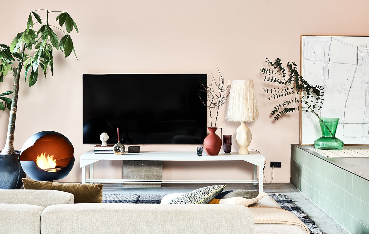 Televisie Samsung 82TU8000, 82 inch € 1349,- (samsung.nl). Sidetable, 59x248x50 cm (dxbxh), prijs op aanvraag (combitex.nl). Bio-ethanol haard Vauni, 60x58x90 cm (bxdxh) € 3195,- (haardcenter.nl). Zandkleurige aardewerken lampenvoet Boho, 58 cm (h) € 189,-, handgemaakte lampenkap Boho Abaca, 28×56 cm (Øxh) € 179,-, donkergroen velvet kussen, 60×40 cm (bxh) € 29,95, kussen met bloemenprint van by Doris voor HKliving, 35×60 cm (bxh) € 37,95, wit kunstwerk Brutalism, 123×163 cm (bxh) € 595,-, groene glazen bijzettafel Hk-mta2860 gebruikt als vaas € 229,- (hkliving.nl). Ronde vaas van Bloomingville, hier gebruikt als kandelaar, 19,5 cm (h) € 36,95, ecomix gerecycled papier-maché hoofd van vtwonen, 20 cm (h) € 34,95, houten blokkandelaar van vtwonen, 15x15x7,5 cm (bxdxh) € 19,95, donkerrode vaas van Pols potten, onderdeel van set van 3 € 220,-, bruine glazen vaas Belise, 11×18,5 cm (Øxh) € 39,90, crèmekleurig kussen van Bloomingville, 40×40 cm € 49,90 (vtwonen.nl). Karpet Jazz, 160×230 cm € 415,- (zuiver.nl). Plaid op de bank, 140×190 cm € 35,99 (zarahome.com). Ecru wollen vloerkleed, 80×130 cm (ottomania.nl). Overig privébezit. vtwonen 2-2022 | styling Esther Jostmeijer | fotografie Bart Brussee | assistentie Esther de Leeuw, Fleur Kant, Monique Vink | met medewerking van Combitex