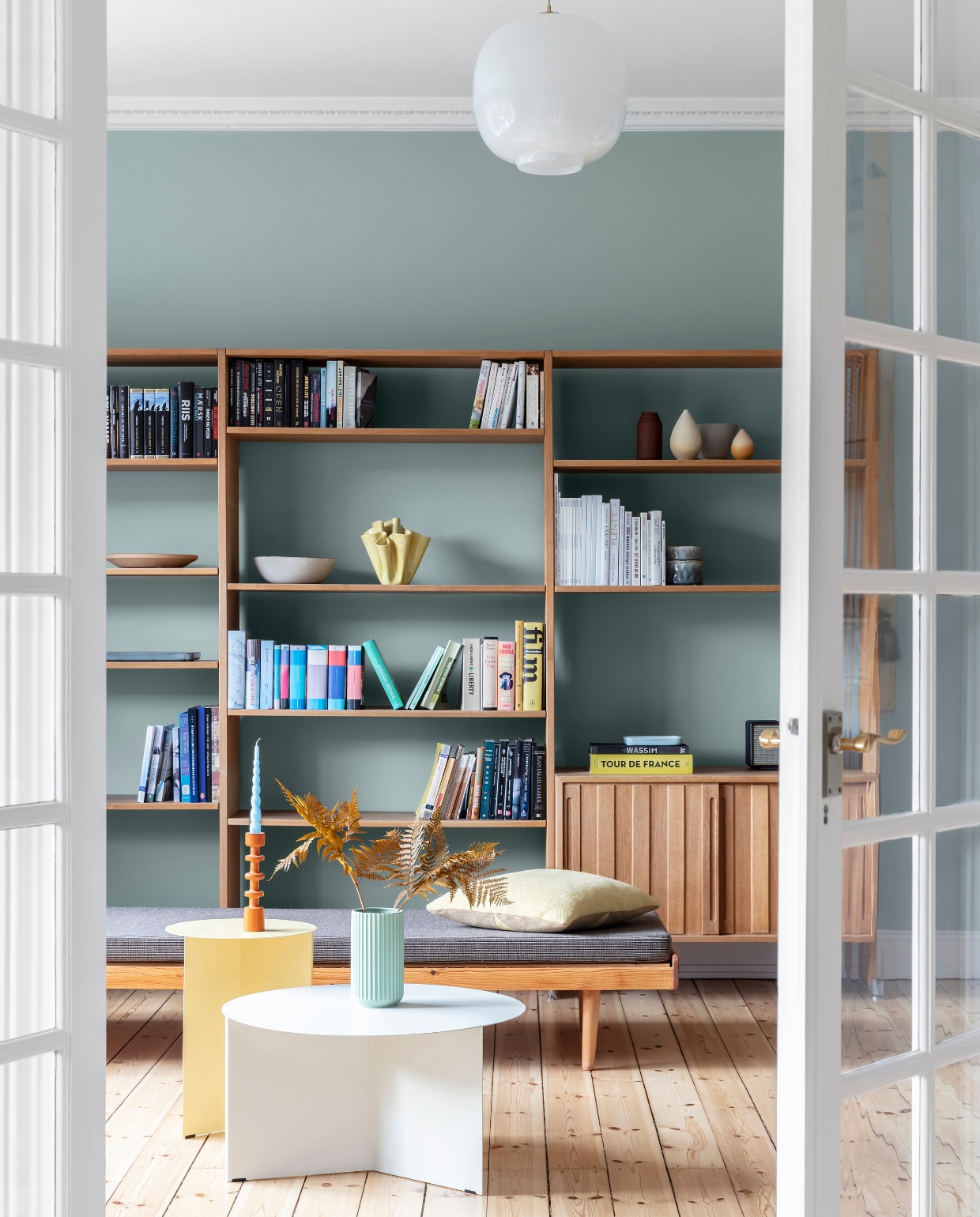 Muurverf Tender Green van Jotun. Originele houten vloer, gerestaureerd. Kast vintage Wegner, gekocht op veiling. Daybed vintage, gestoffeerd met wol van Kvadrat / Raf Simons. Hanglamp Radio House. Prikbord Ikea. Salontafels Hay. Groene vaas Lyngby Porcelæn. Kandelaar vintage. vtwonen 09-2022 | productie Living Inside | styling Rikke Graff Juel | fotografie Christina Kayser O.