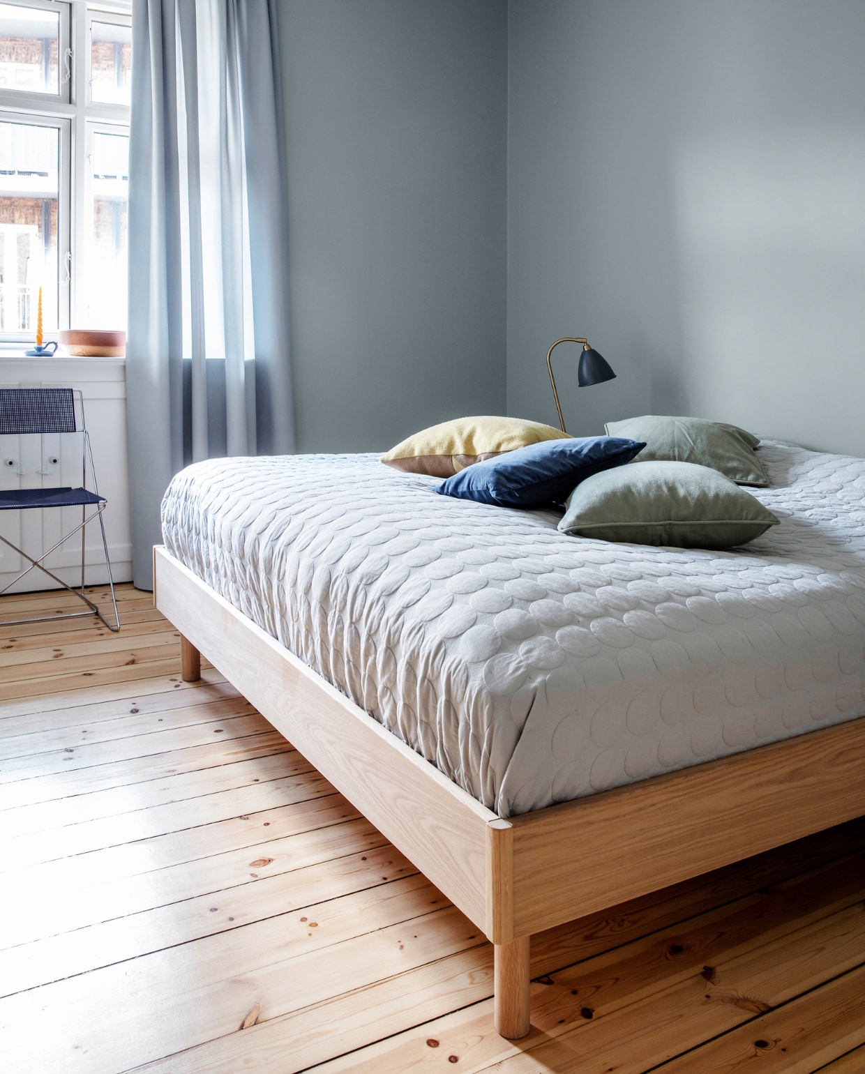 Muurverf Exhale van Jotun. Gordijnen Kvadrat. Bedsprei en kussens Hay. Tafellamp Gubi. Stoel uit lijn van Nie Kvadrat. Overig herkomst onbekend. vtwonen 09-2022 | productie Living Inside | styling Rikke Graff Juel | fotografie Christina Kayser O.