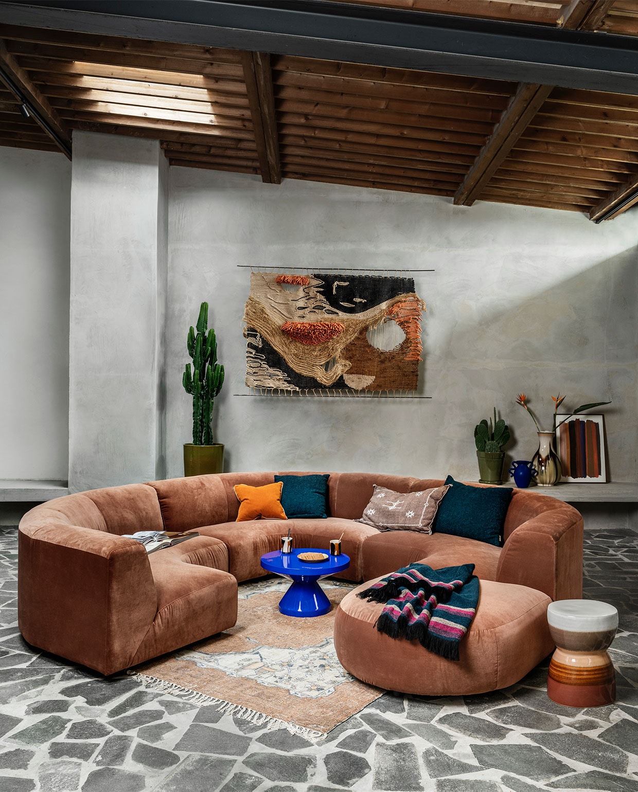 Ribfluwelen bank Vint van HKliving, element vanaf € 495,-, ronde poef met zwarte streep van Kave Home, 40×45 cm (hxØ) € 81,-, vierkante rotan poef van Kave Home, 50×50 cm € 87,-, mok met oor van Bloomingdale € 11,35, theekop met oor van HKliving € 10,30, oranje kussen van Hay € 75,-, poef Macaroni in geel velours van BePureHome, 42x162x80 cm (hxbxd) € 319,-(vtwonen.nl). Handgemaakt roze wollen vloerkleed, 260×360 cm € 2495,-, ronde rieten salontafel, 36×81 cm (hxØ) € 569,-, oranje glazen plaat € 150,-, lampenvoet € 139,-, lampenkap € 129,- (hkliving.nl). Poef met raffiafranje, 42x42x47 cm (hxbxd) € 129,-, bruin kussen met borduursel € 99,- (zenza.nl). Glazen vaas € 159,-, hoogpolig kussen € 119,- (fermliving.com). Gevlochten schaal € 39,-, bekers met terra glazuur € 7,50, wollen plaid € 395,- (householdhardware.nl). Theepot € 49,- (hay.dk). Beamer The Premiere van Samsung, vanaf € 2599,- (samsung.com). Pot en plant, prijs op aanvraag (dennisflowers.nl). vtwonen 02-2022 | styling Marianne Luning | fotografie Stan Koolen