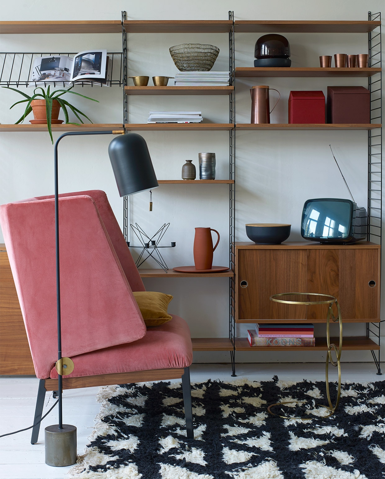 Lounge chair Hug van Arflex, zithoogte 44 cm, rughoogte 103 cm € 2704,-, kast String in uitvoering 200x215x30 cm (hxbxd) € 1988,-, vloerlamp € 586,- (Mobilia). Wollen vloerkleed Indochine Nights, 140×200 cm € 419,- (Aai Made with Love). Bijzettafel van Madam Stoltz € 145,- (deens.nl). In de kast: Kandelaar in stervorm van ijzerdraad € 31,-, schaal van ijzerdraad € 27,50, zwarte schaal met deksel € 36,50, vaasjes van Madam Stoltz vanaf € 6,95 (deens.nl). Koperen kan met houten deksel € 49,95, koperen bekers € 8,95, messing bekers € 15,95 (Nijhof). Glazen lamp van Menu € 229,95, terra kan en schaal van SCP € 139,-, rode en bruine dozen van Menu, per set van 3 stuks € 69,95 (Mobilia).  vtwonen 01-2017 | styling Marianne Luning | fotografie Tjitske van Leeuwen