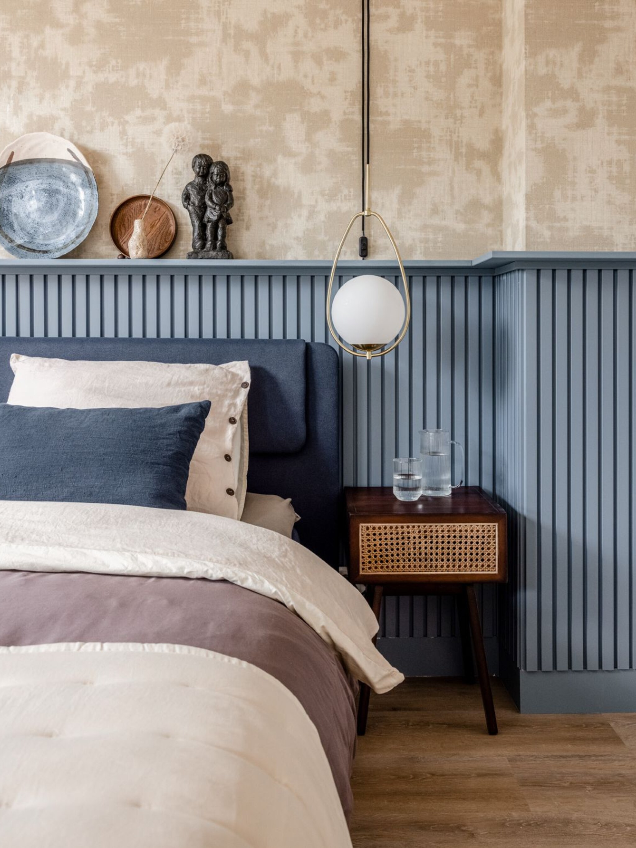 woonidee behang en een lambrisering achter het bed voor een hotel chic sfeer
