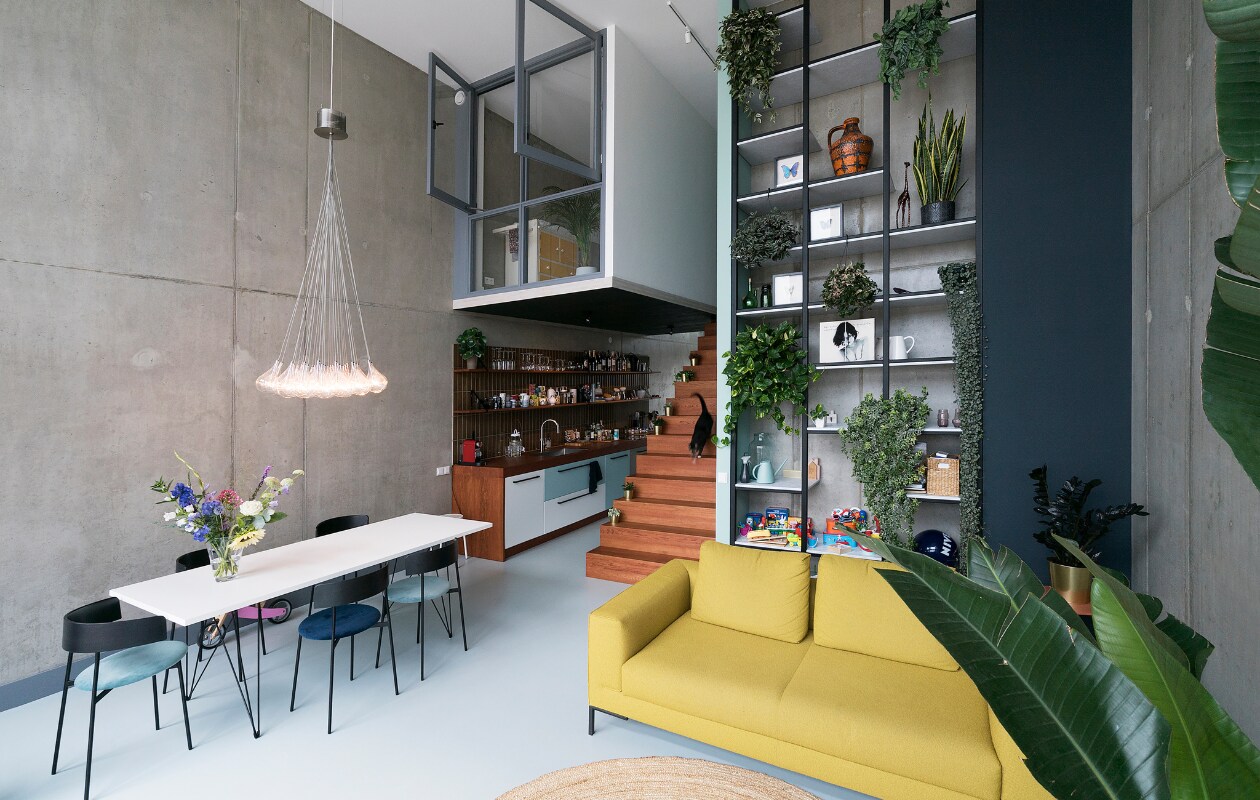 Bank Aikon Lounge van Design on Stock. Eetkamerstoelen Friday van Fest. Tafel Magis Tavolo XZ3 via Flinders. Maatwerkkeuken, eikenhouten trap en stalen kast ontwerp Martijn Frank Dirks, uitvoering Spinder Interieurbouw. Inbouwapparatuur Siemens. Downdraft afzuiger Wave Design. Tegels Ceramiche Grazia 6,6×26 cm in kleur Pepe. Vloer DGF polyurethaan PU Gietvloer in kleur NO.05.65 via Design Gietvloer Amsterdam. Betonnen muren geïmpregneerd met Hydrablock Pro voor matte look. Gouden bloempotten Ikea. Grijze verf Sikkens ACC Aqua Zijdeglans kleur SN.02.57. Donkerblauwe verf Sikkens ACC Aqua Zijdeglans kleur SO.10.20. NEE | vtwonen 09-2022 | styling Emmy van Dantzig | fotografie Jansje Klazinga | tekst Martine de Hoog