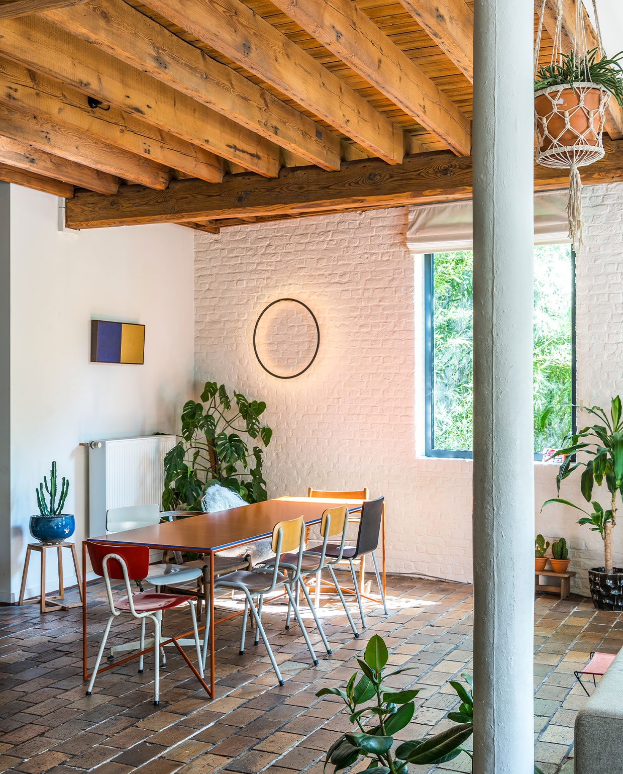 Schilderij Russell Scarpulla, kruk en tafel Piece van Maria Scarpulla, lamp Eclipse van Tilen Sepic, schoolstoelen en draaistoel straatvondst. Andere stoelen Vitra .03 van Maarten Van Severen, Wishbone Chair van Hans Wegner en Bertoia Side Chair van Harry Bertoia voor Knoll. Kop Kolonel leger, theepot Bornn Enamelware, vaas erfstuk grootmoeder. NEE | vtwonen 6-2022 | Productie Living Inside | Fotografie Luc Roymans | Tekst Mirjam Rosema-Verhulst