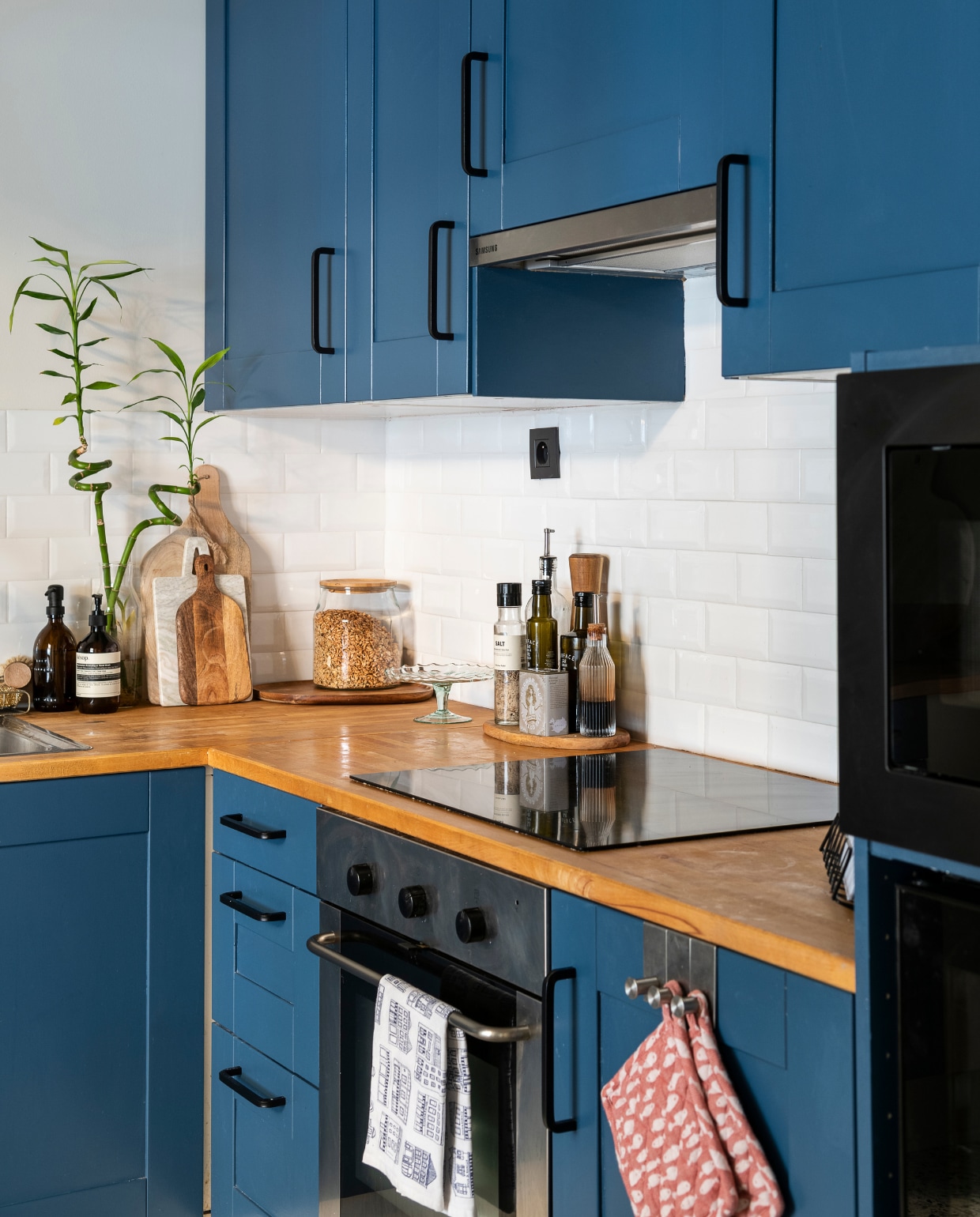 Keukenkasten en werkblad Ikea, kasten geschilderd met Ck Dc 9-c Boss Paints via Colora. Terrazzo vloertegels Impermo, verlichting en ronde mat Westwing, roze vuilnisbak Made, koffiemachine Sage, snijplanken H&amp;M Home, wandplank zelfgemaakt, lijst allthewaystosay.com, letterbord Hema, potten Ikea. Vijzel H&amp;M home, handzeep Aeosop. vtwonen 09-2022 | Fotografie Jonah Samyn | Tekst Katrien Depoorter