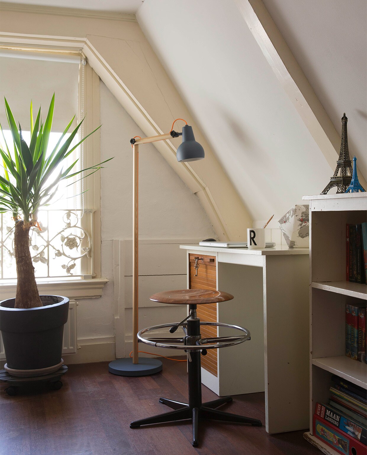 Het bureau, het kastje en de stoel zijn erfstukken. Beker van Design Letters, ontworpen door architect Arne Jacobsen, gekocht bij de Bijenkorf. Plant Yucca. Staande lamp Study (grijs) van Zuiver. Verduisterend rolgordijn Hema. JA | vtwonen 11-2016 | fotografie Dana van Leeuwen
